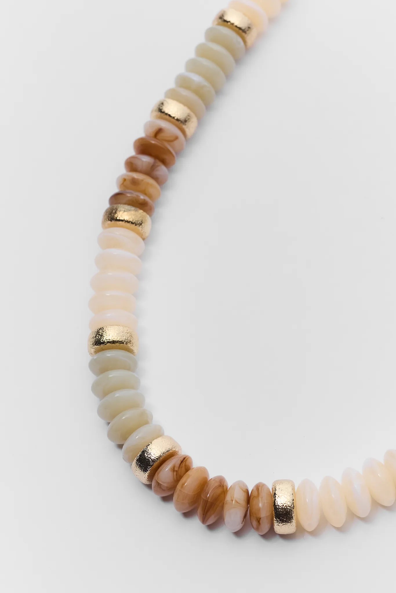 Necklace with beige and brown beads on a white background
