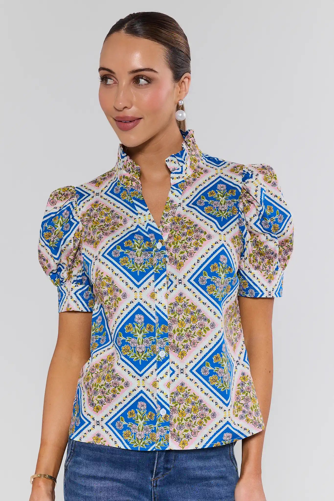 Woman wearing a patterned blouse with a plain background