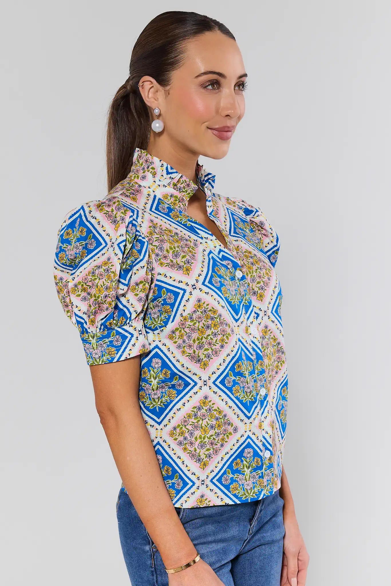 Woman wearing a patterned shirt with a plain background
