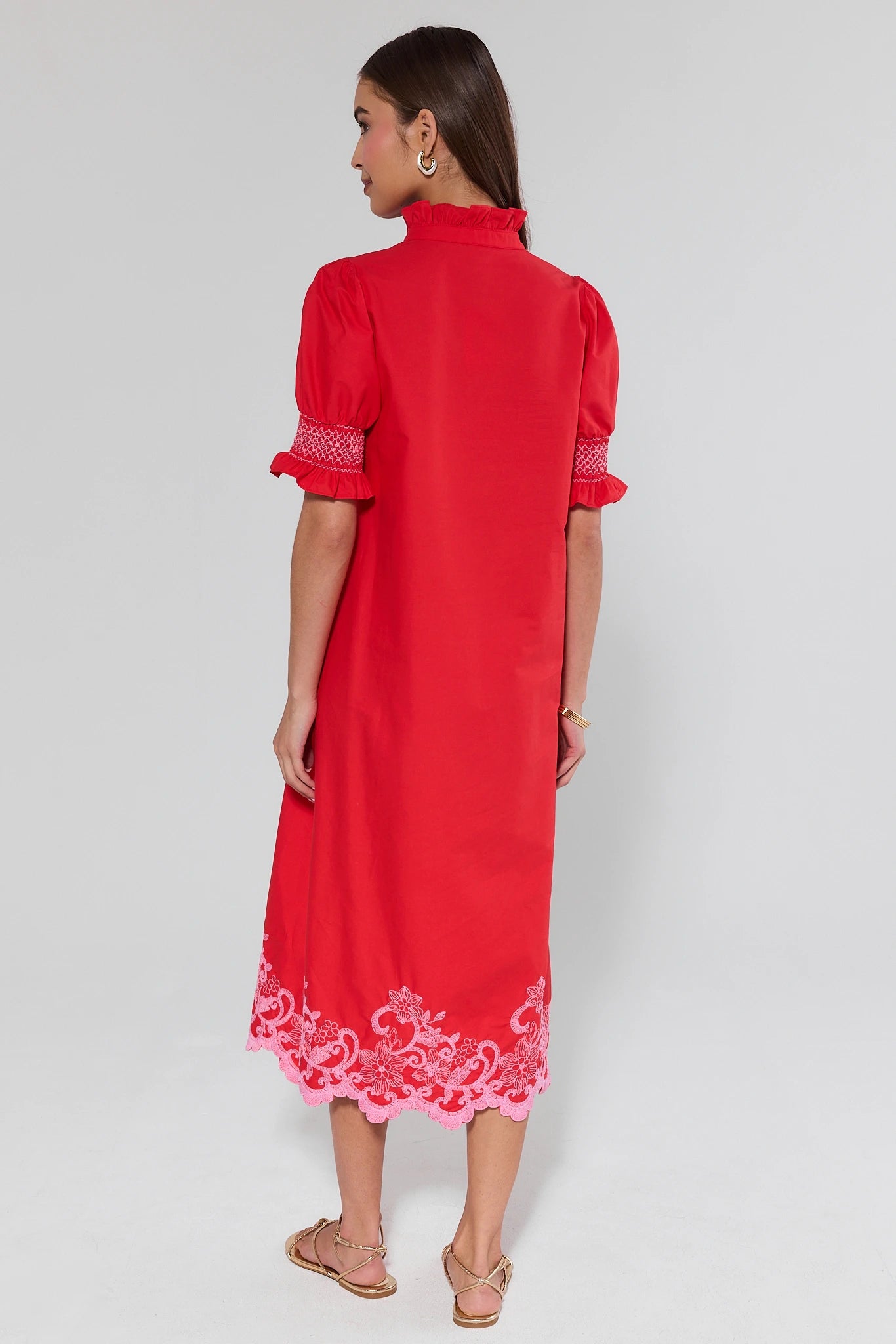 Red dress with white lace details on a plain background
