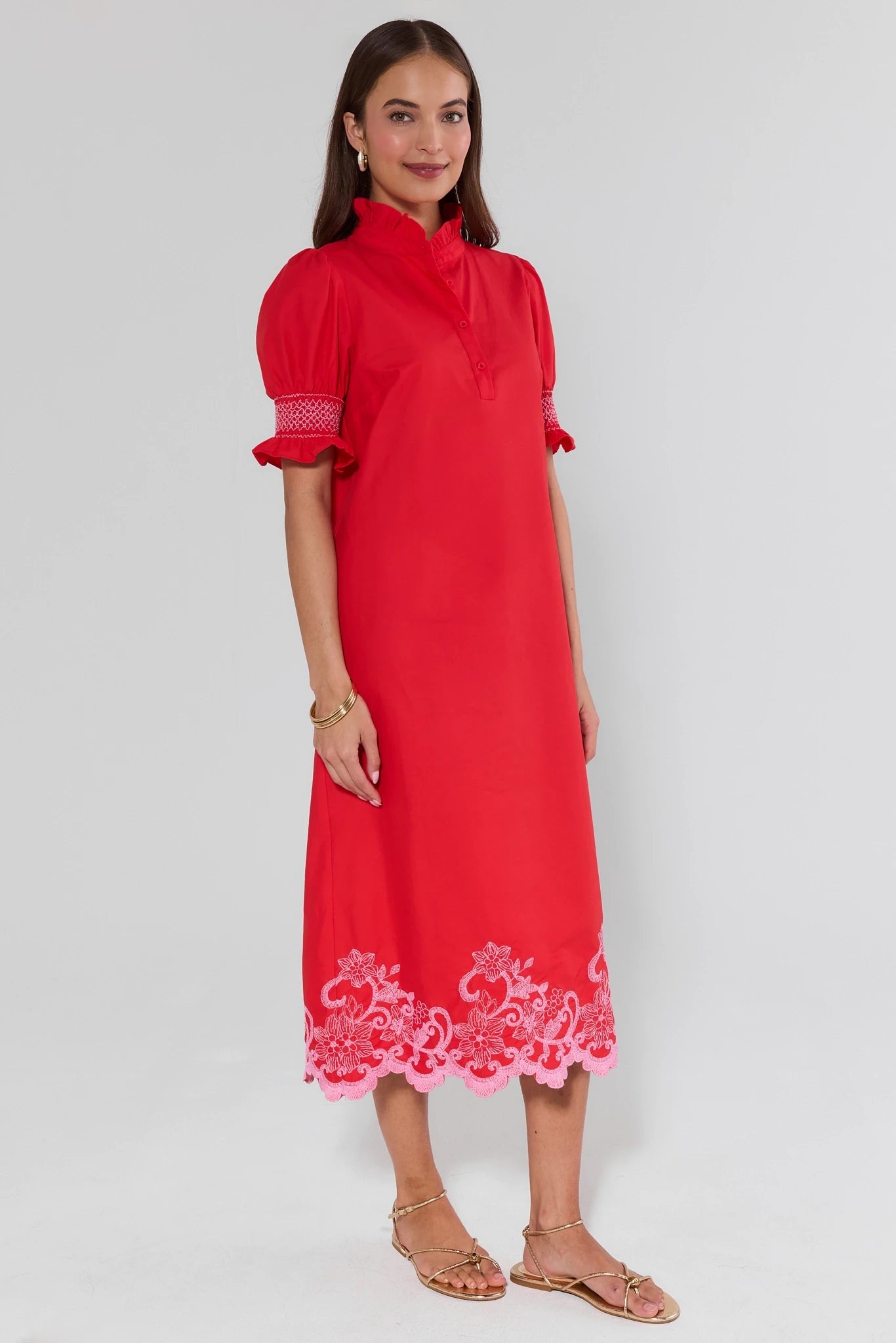 Woman wearing a red dress with lace details on a white background