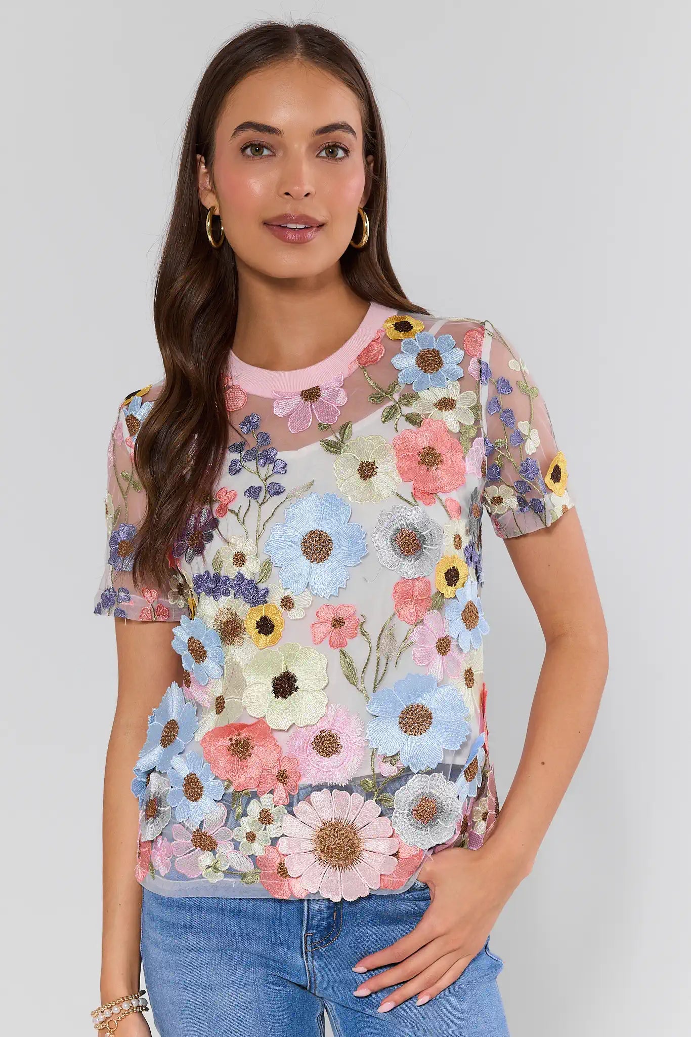 Woman wearing a colorful floral blouse against a plain background