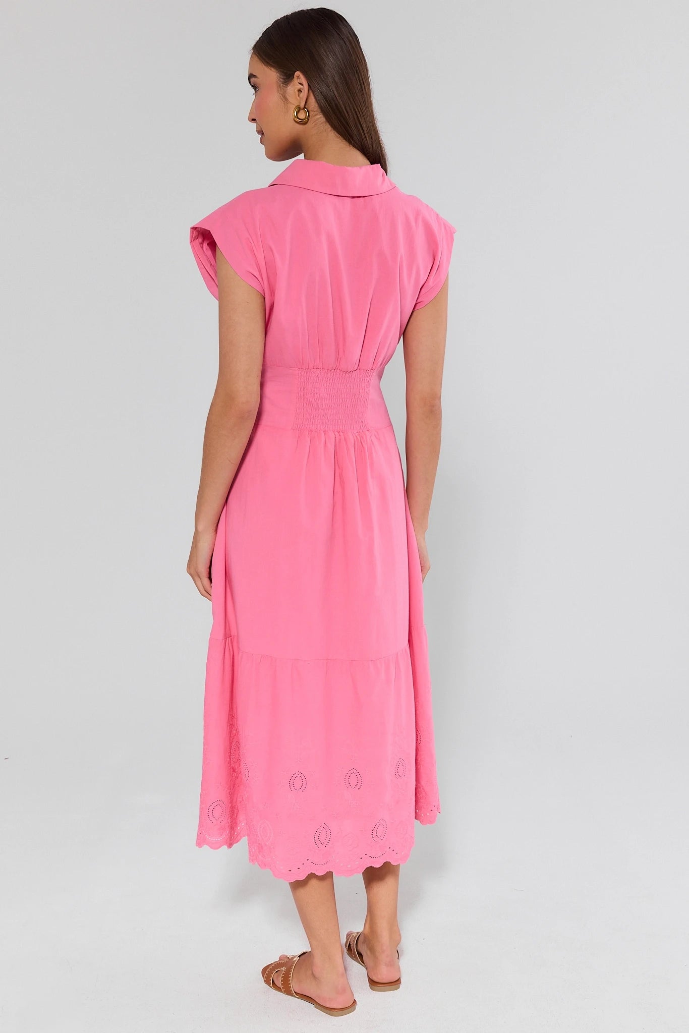 Woman wearing a pink dress on a plain background