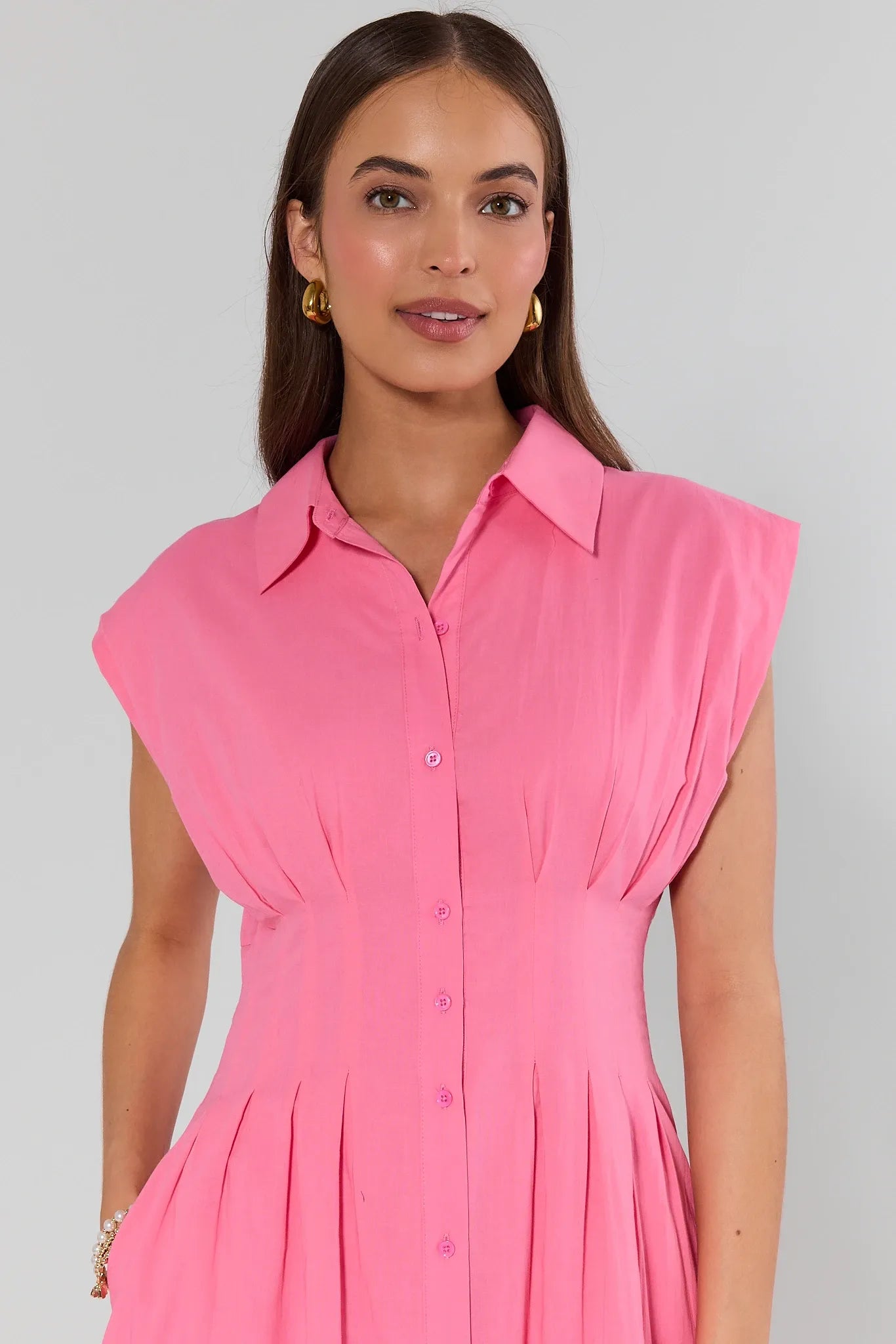 Woman wearing a pink dress against a gray background