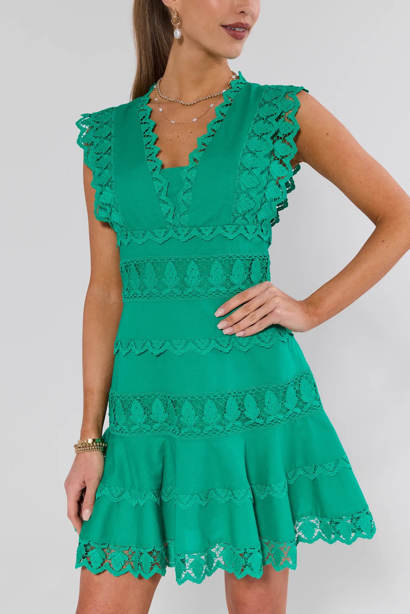 Green lace dress worn by a model on a plain background