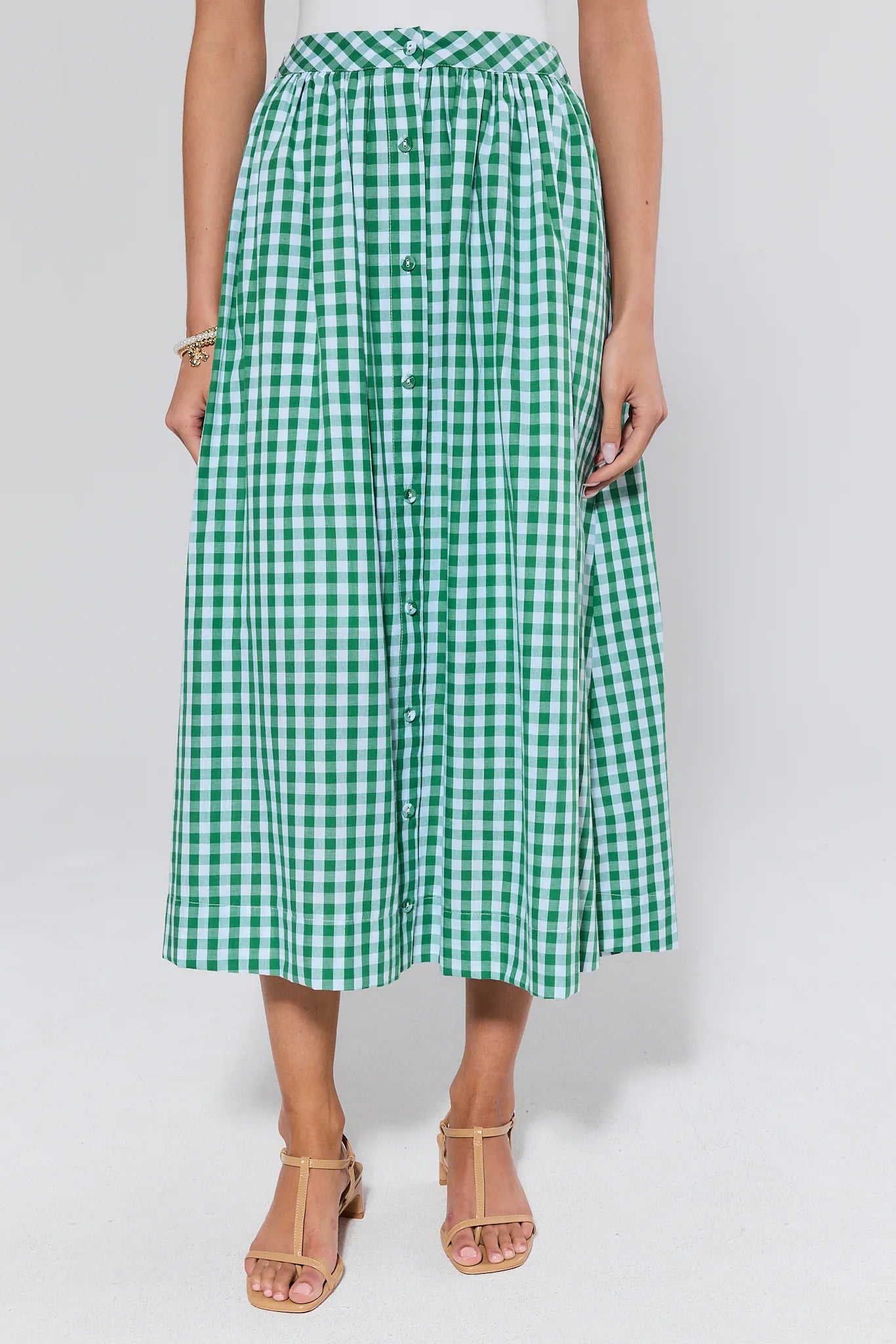 Green and white checkered skirt worn by a person on a plain background