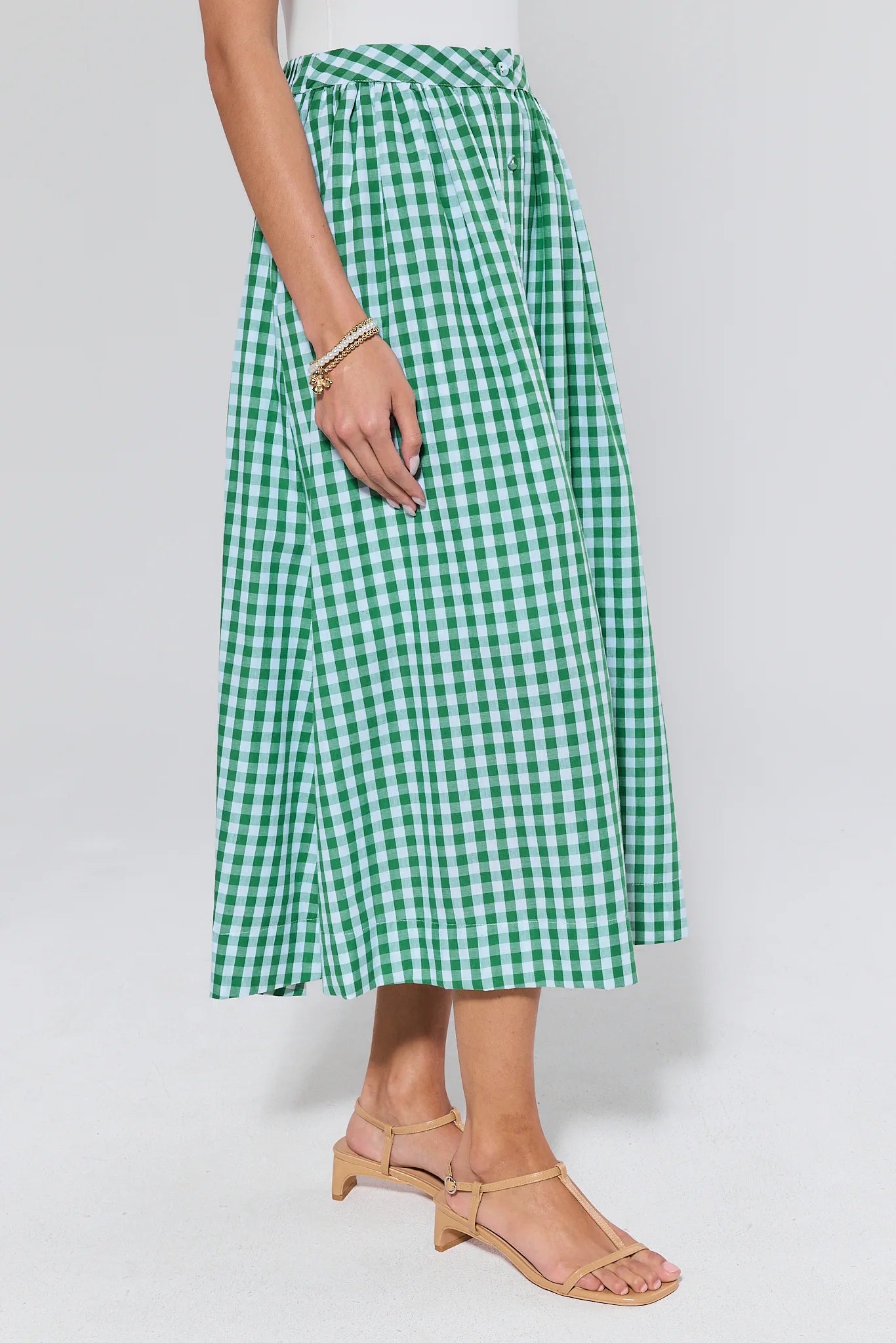 Green and white checkered skirt worn on a plain background