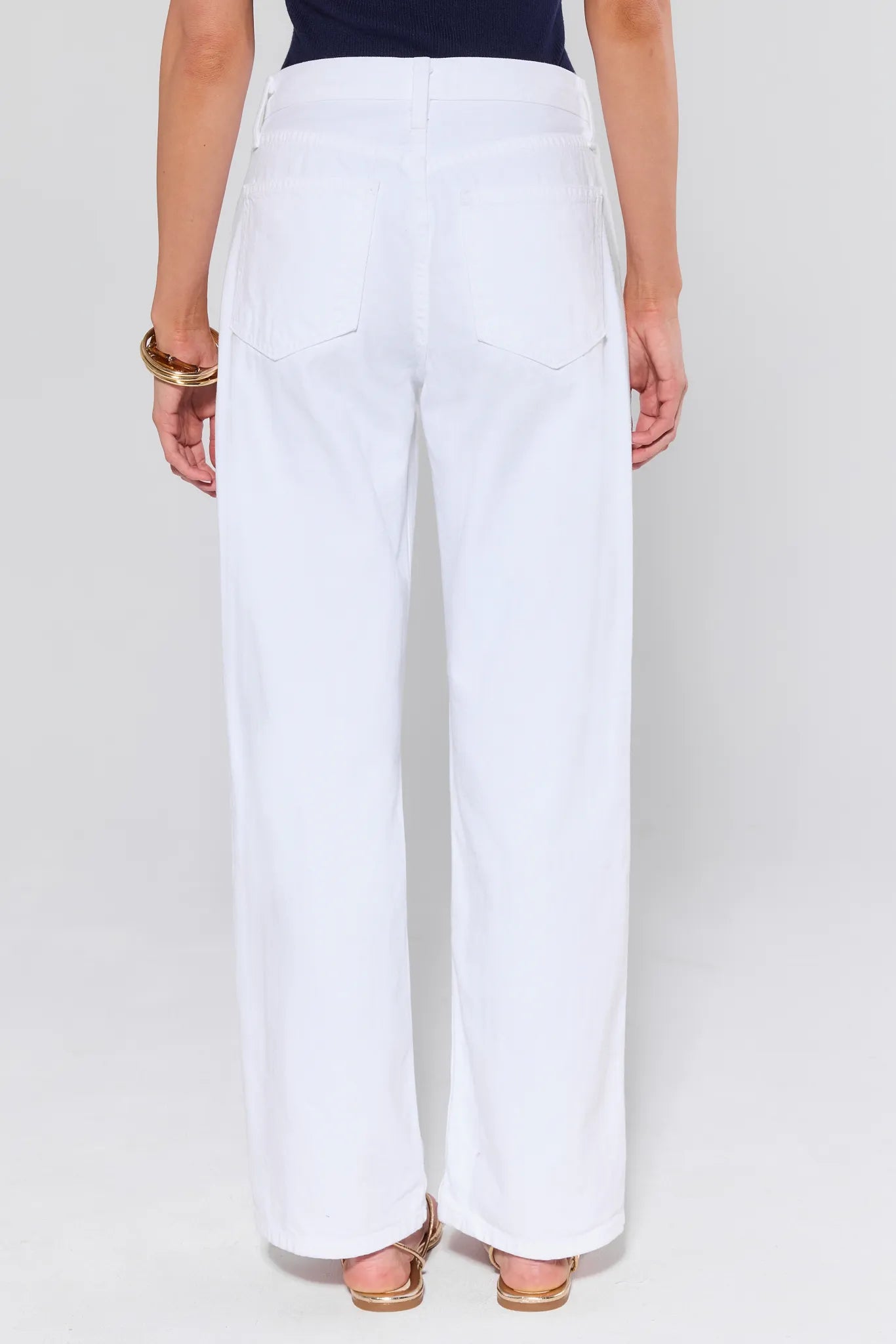 White pants worn by a person on a white background