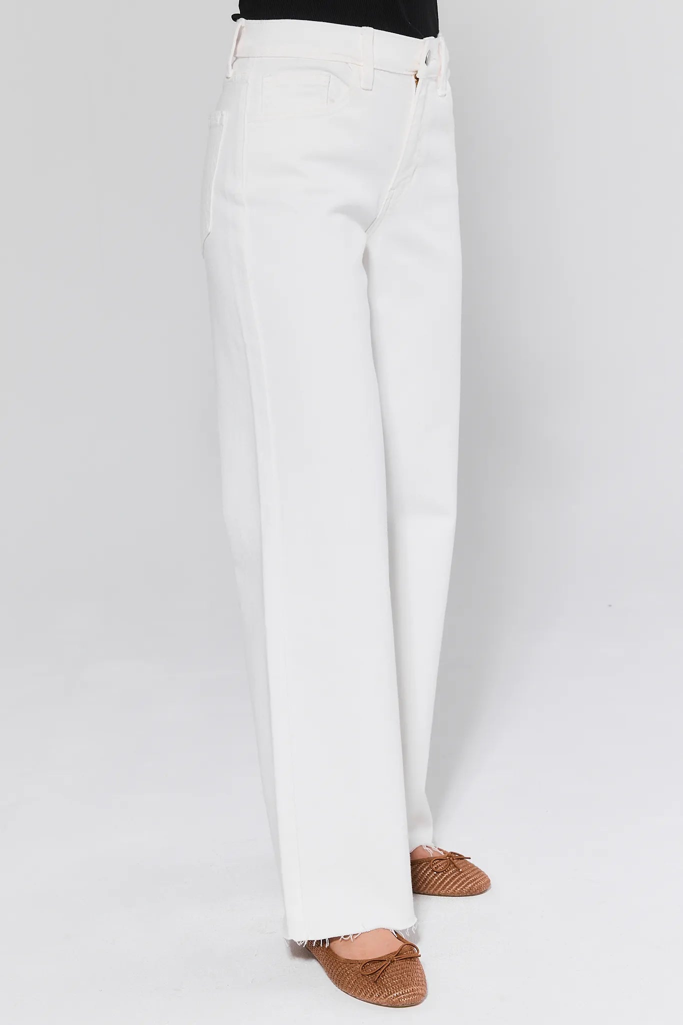 White pants worn by a person on a white background
