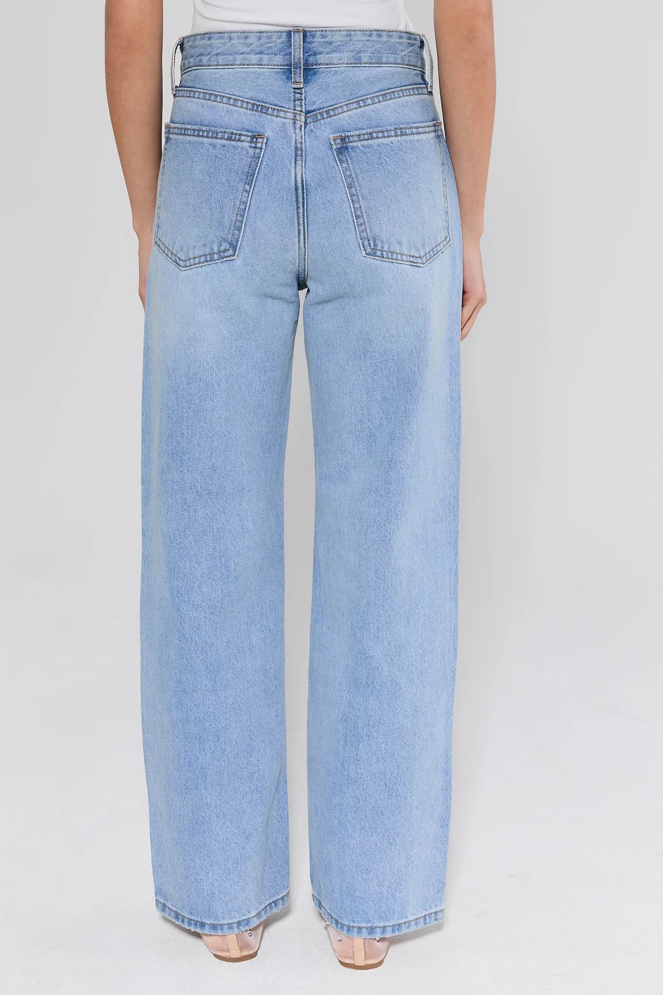 light wash jeans with flats on white background