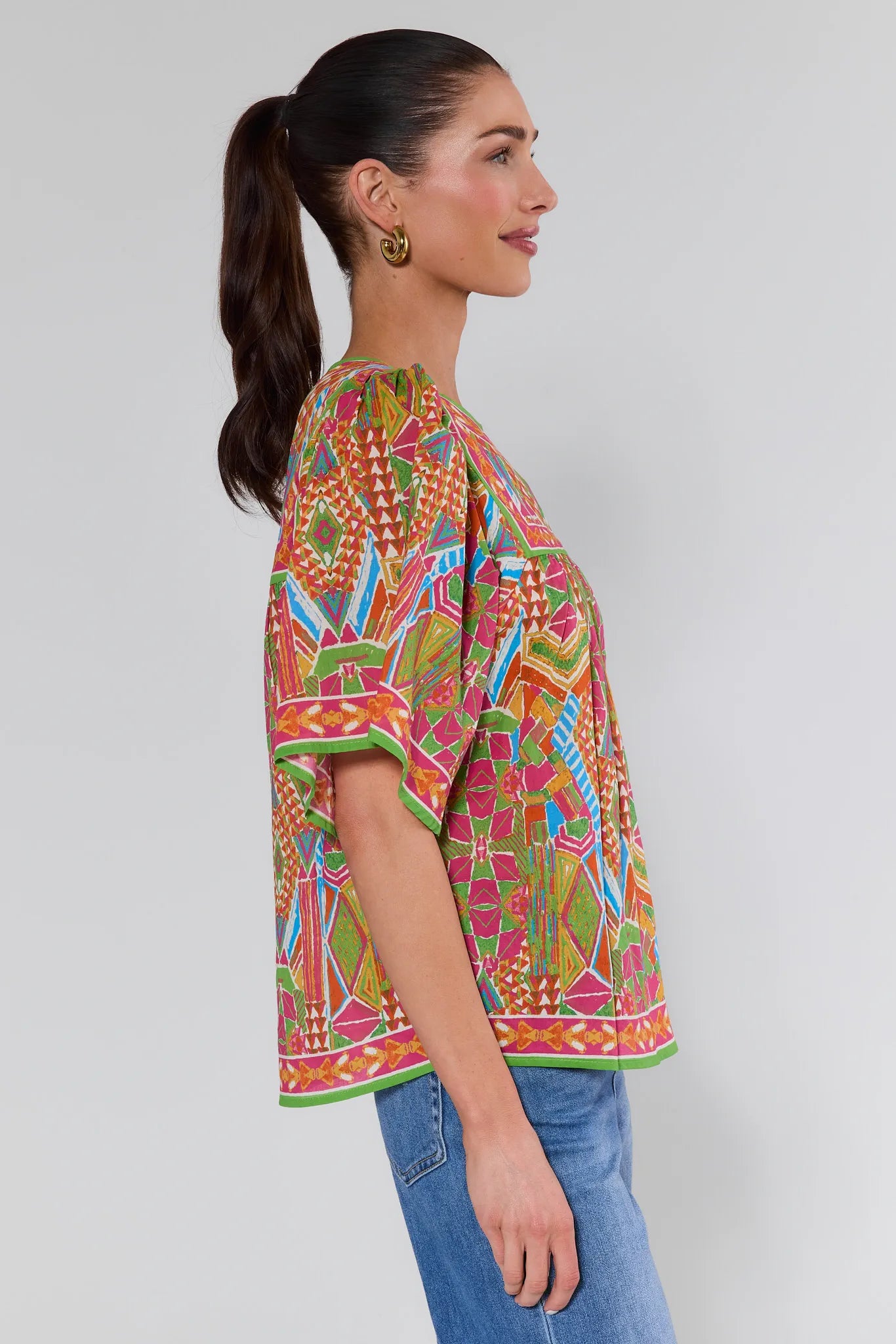 Woman wearing a colorful patterned top with a background