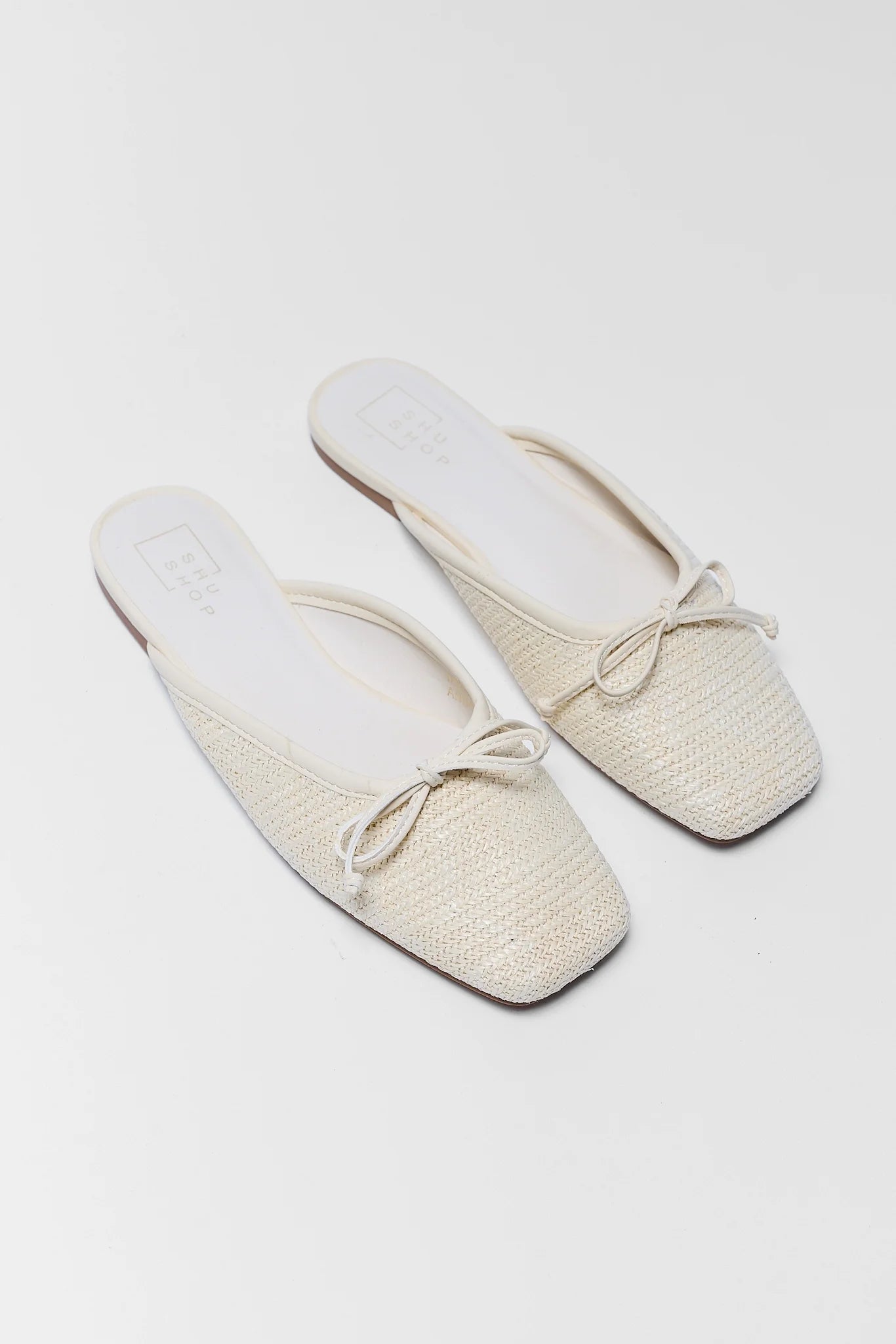 Pair of beige slippers on a white background