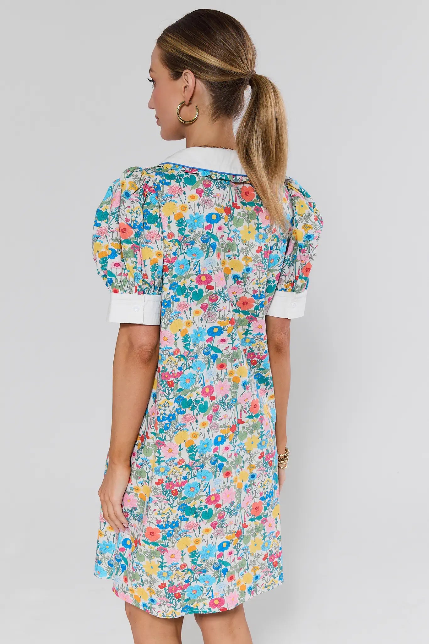 Woman wearing a colorful floral dress on a background back of dress
