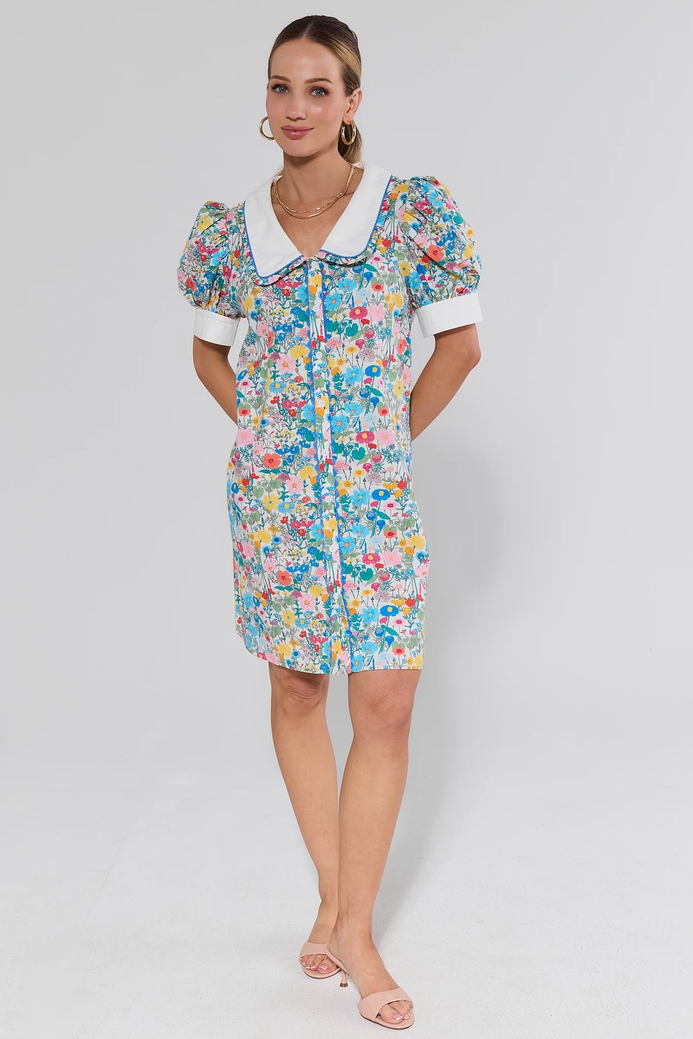 Woman wearing a floral dress with a white collar on a background