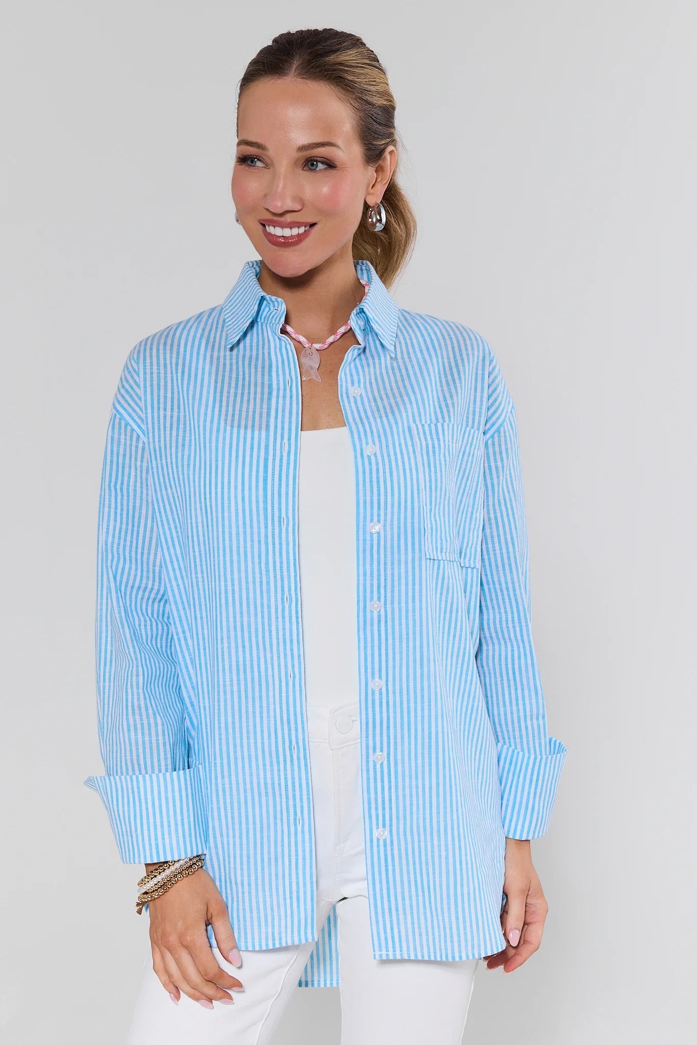 Woman wearing a light blue striped shirt against a white background