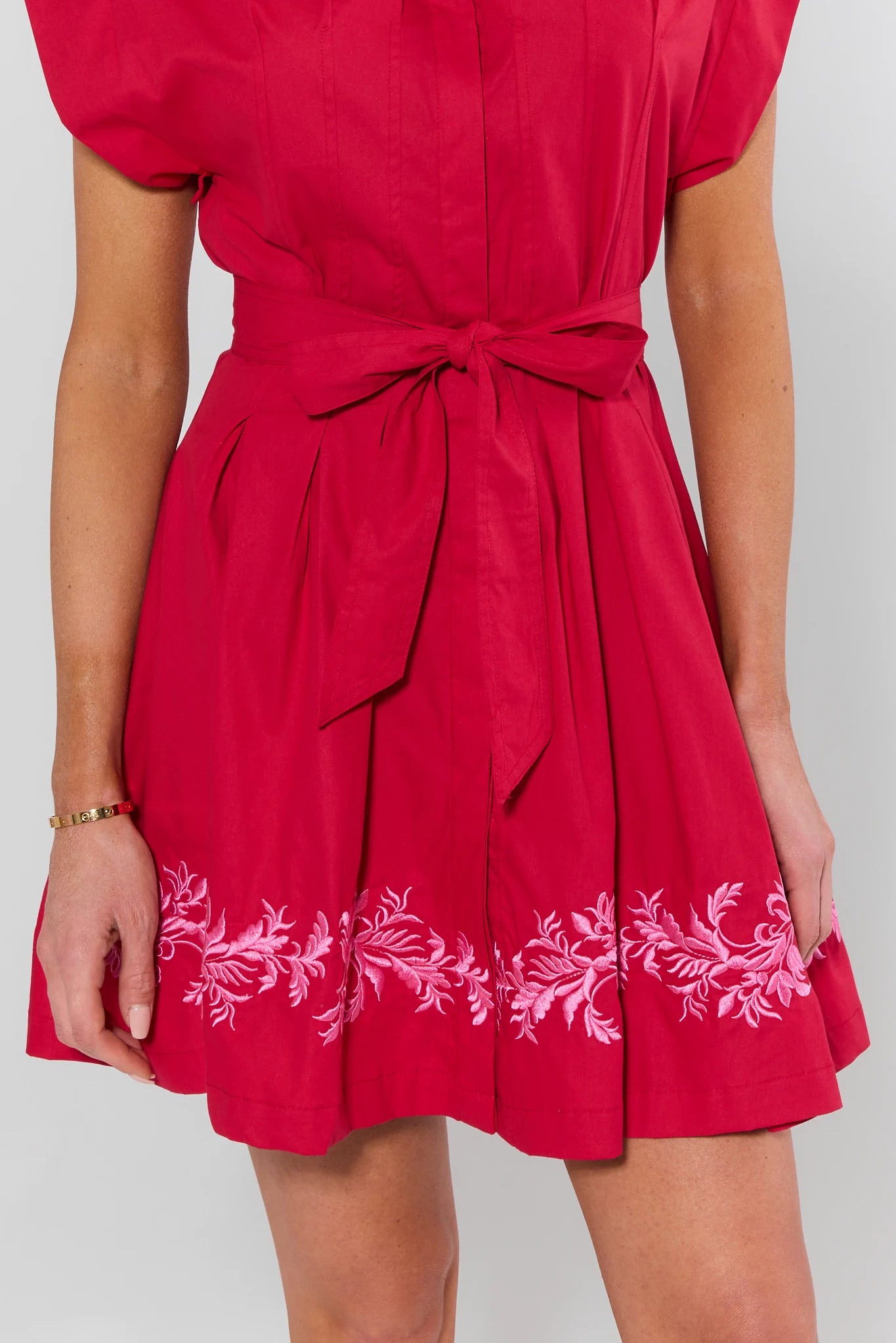 Red dress with white floral embroidery on a plain background