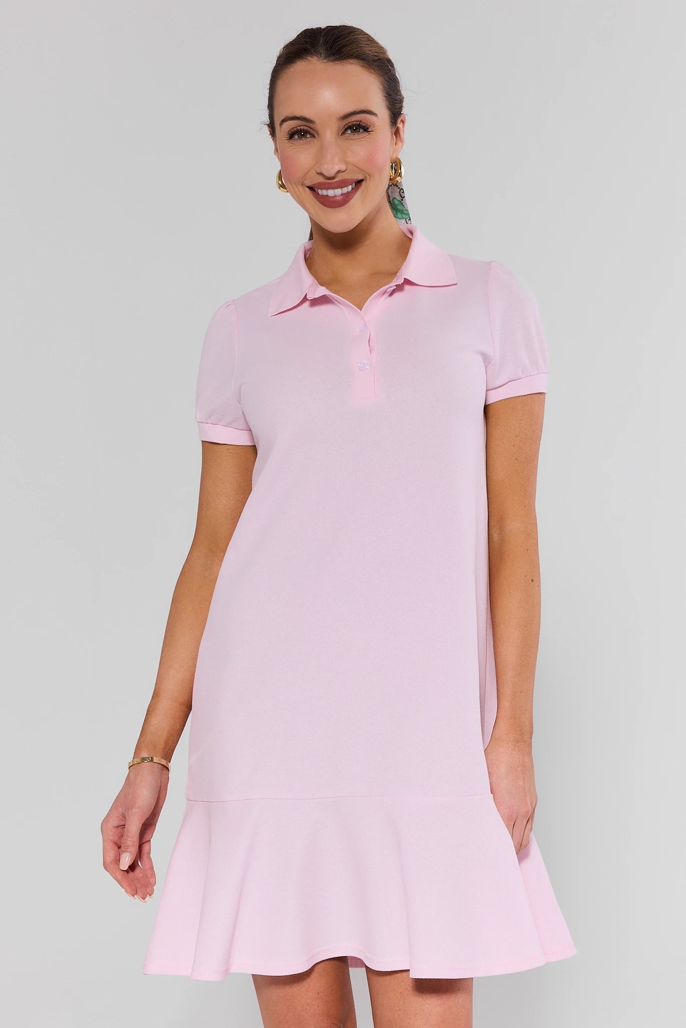 Woman wearing a pink dress against a plain background