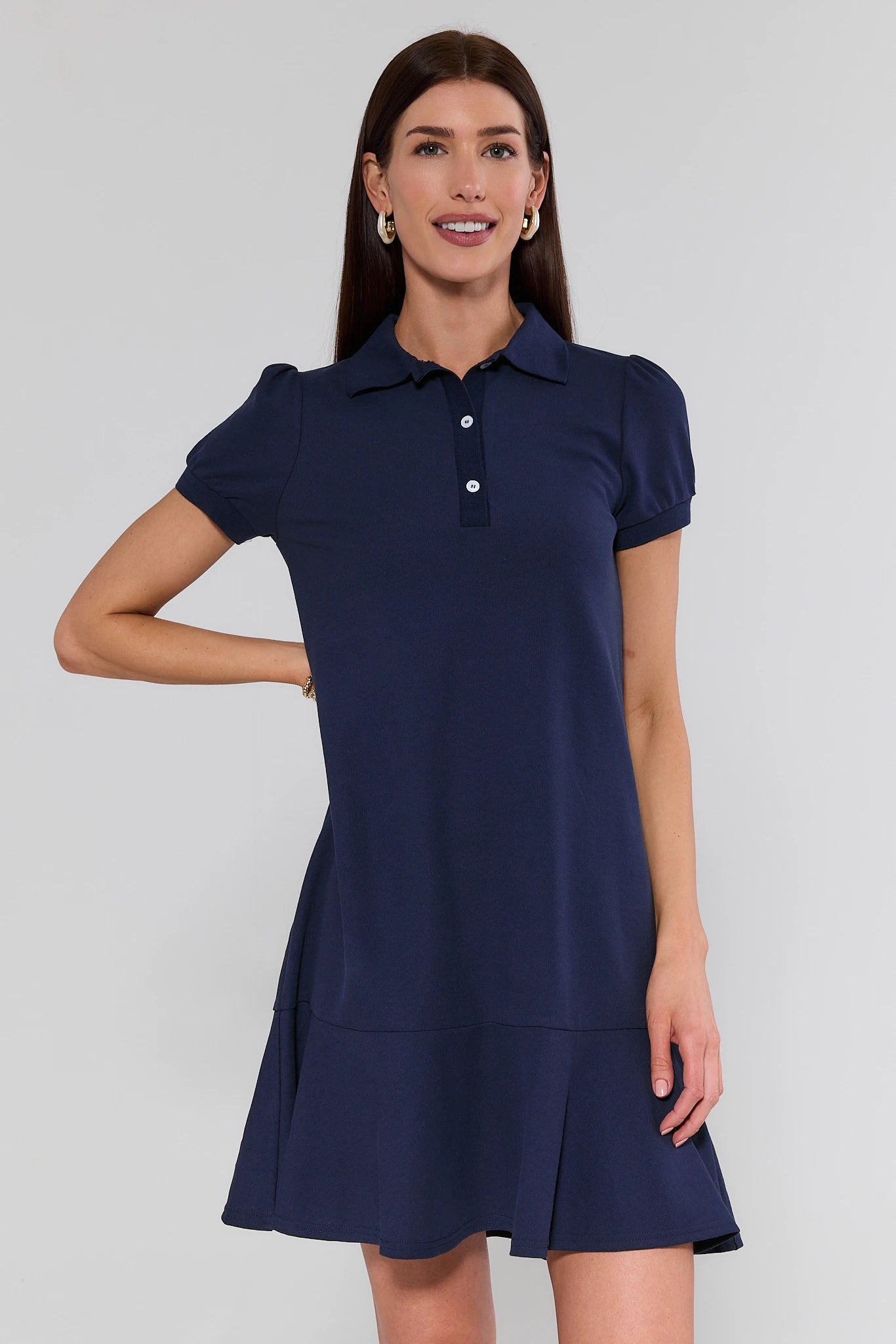 Woman wearing a navy blue dress with short sleeves on a white background