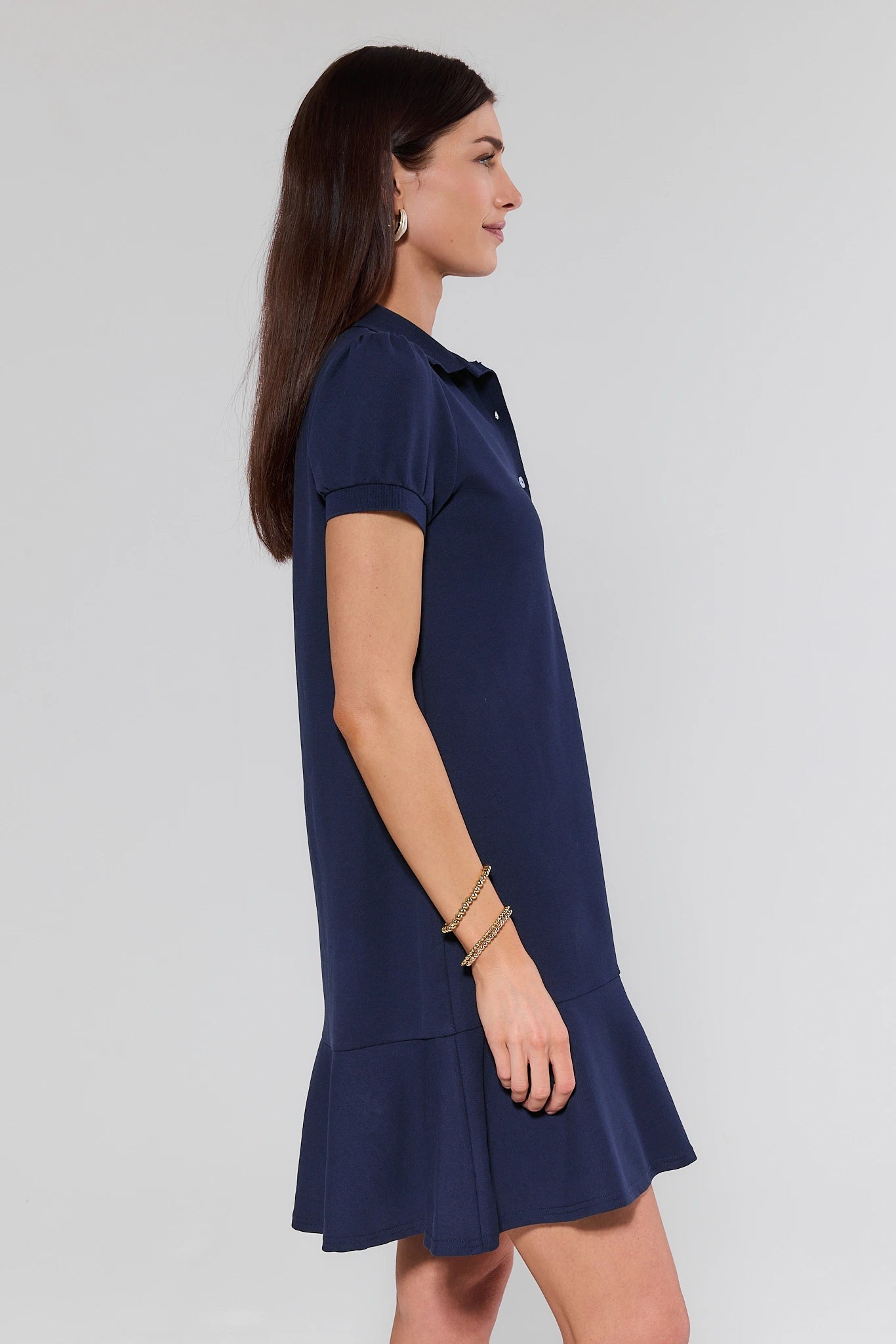 Woman wearing a navy blue dress on a light gray background