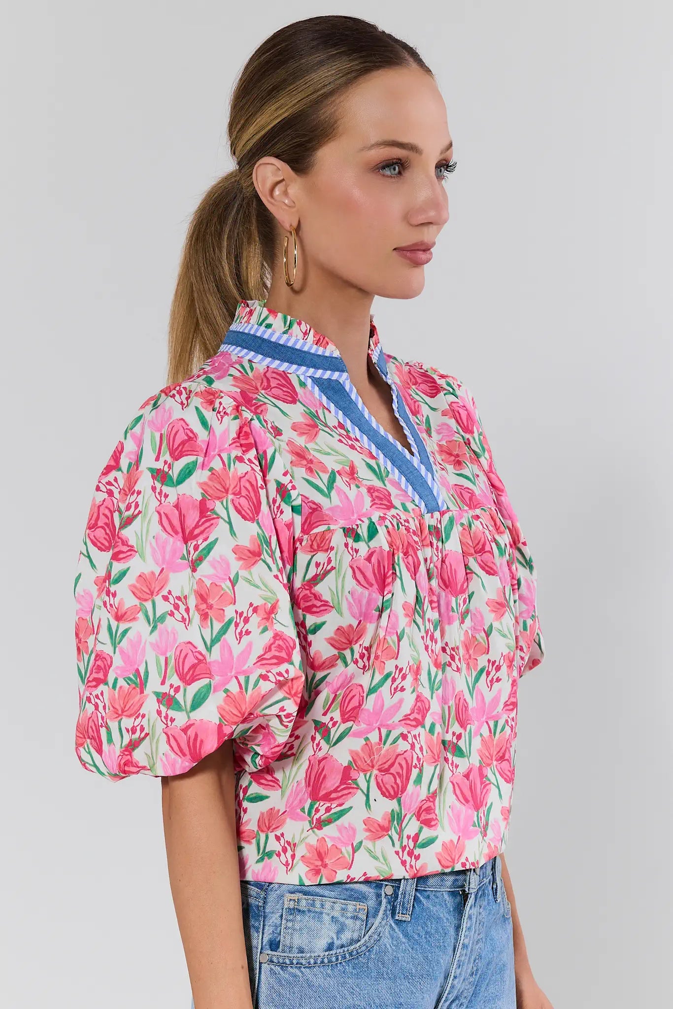 Woman wearing a colorful floral blouse with puff sleeves with no background