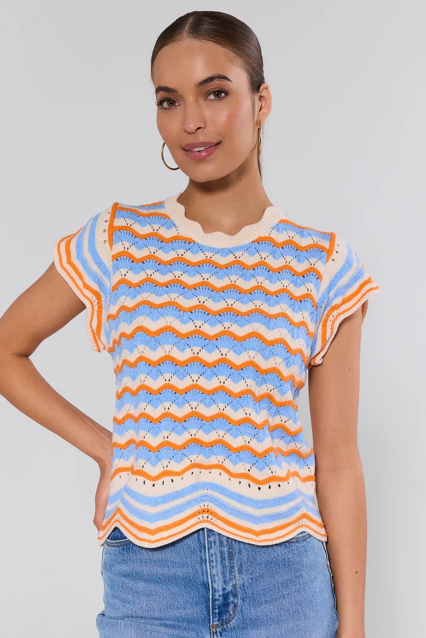 Woman wearing a colorful striped shirt with a plain background