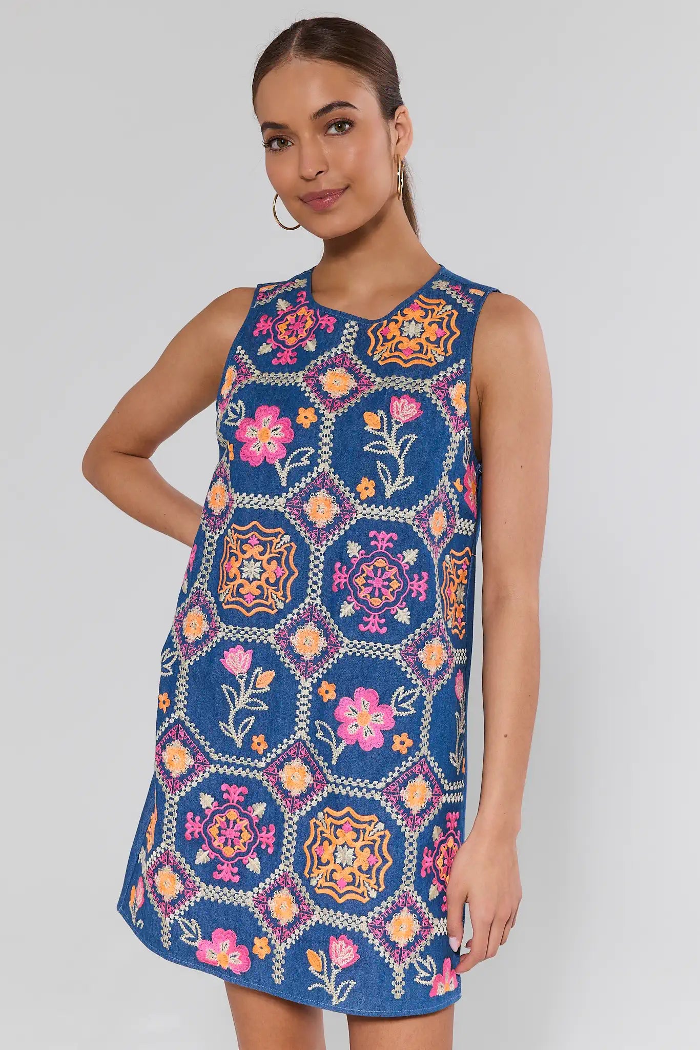 Woman wearing a colorful embroidered dress on a white background