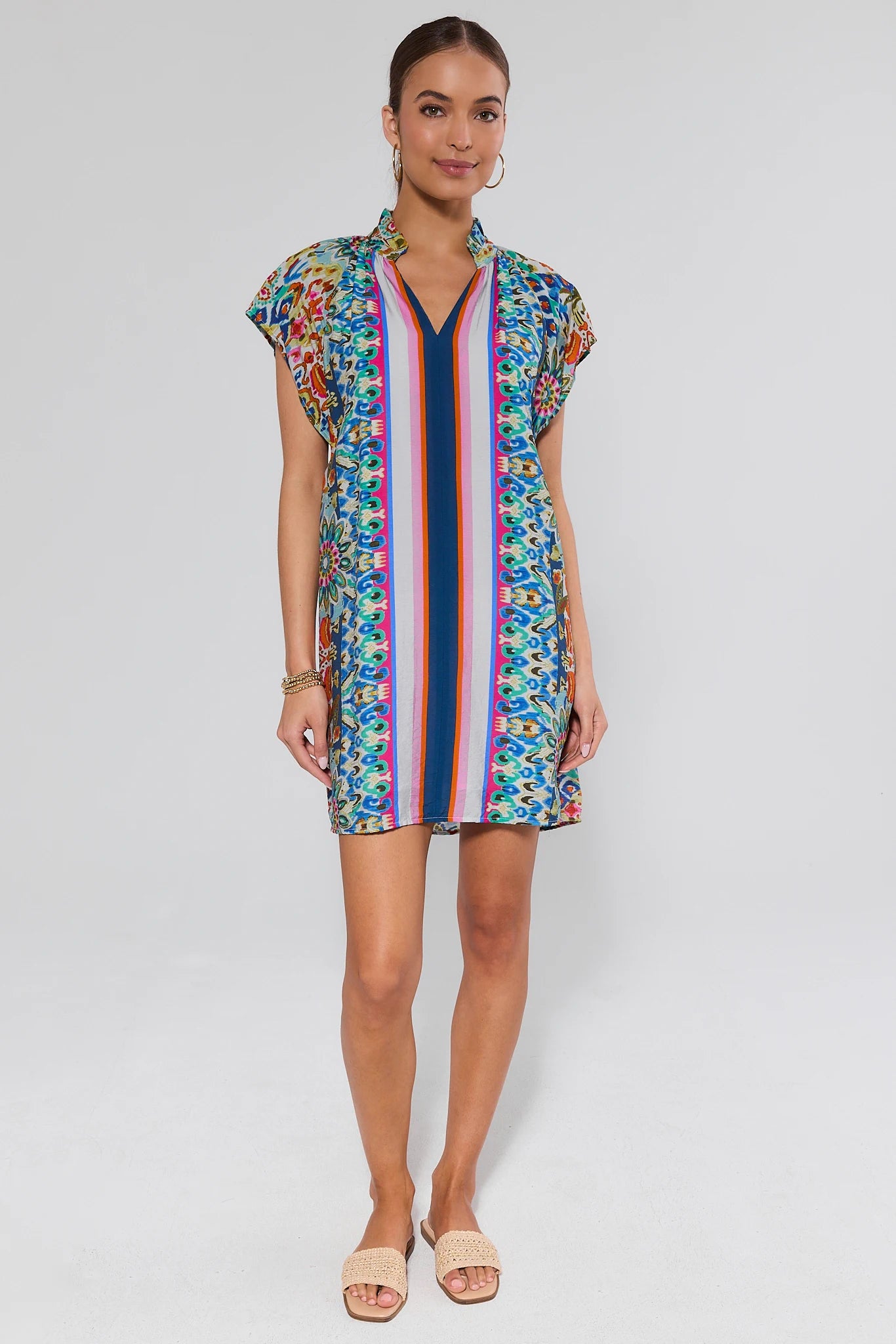 Woman wearing a colorful dress with a striped pattern on a white background