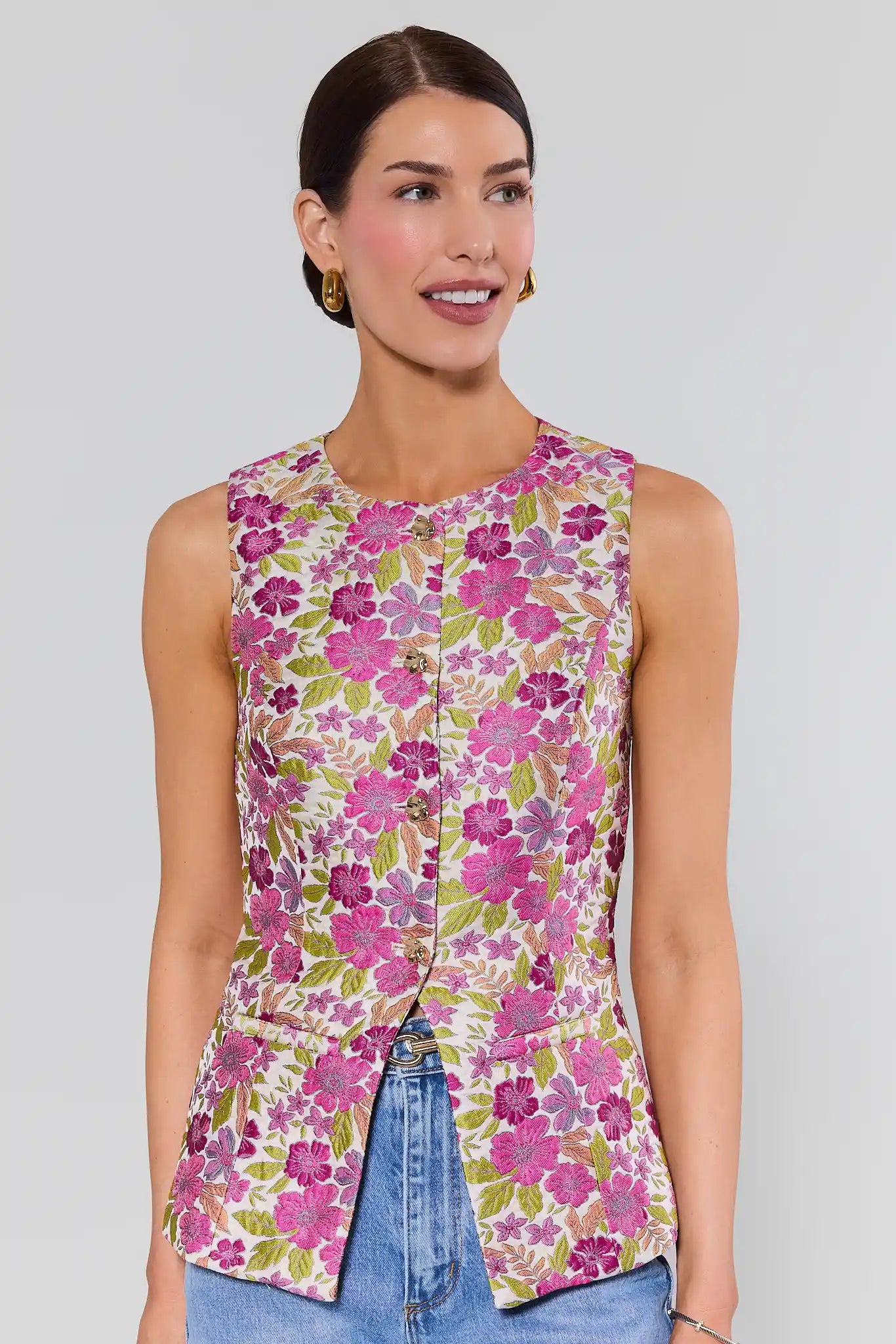 Woman wearing a sleeveless floral top with a plain background