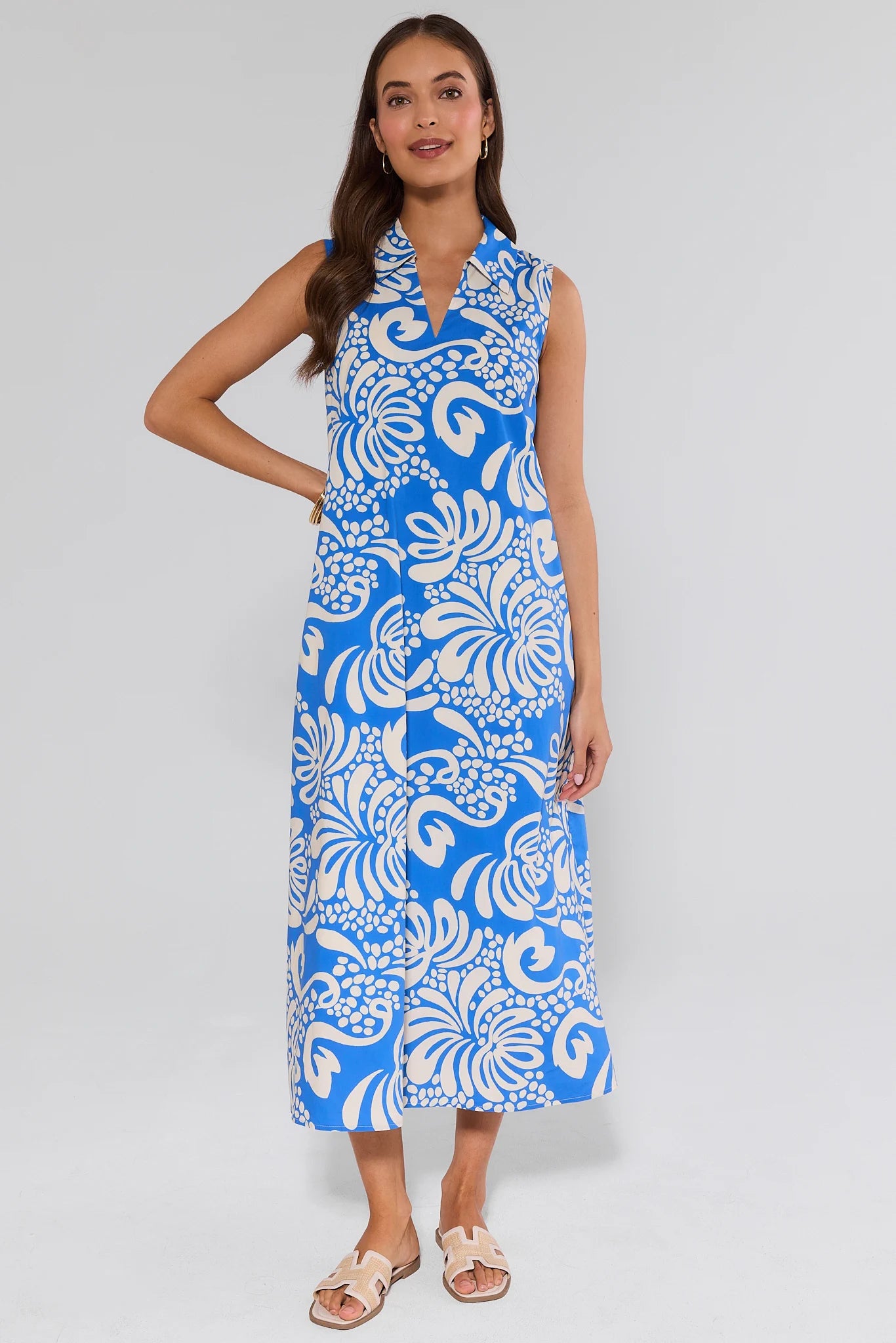 Woman wearing a blue and white floral dress on a gray background
