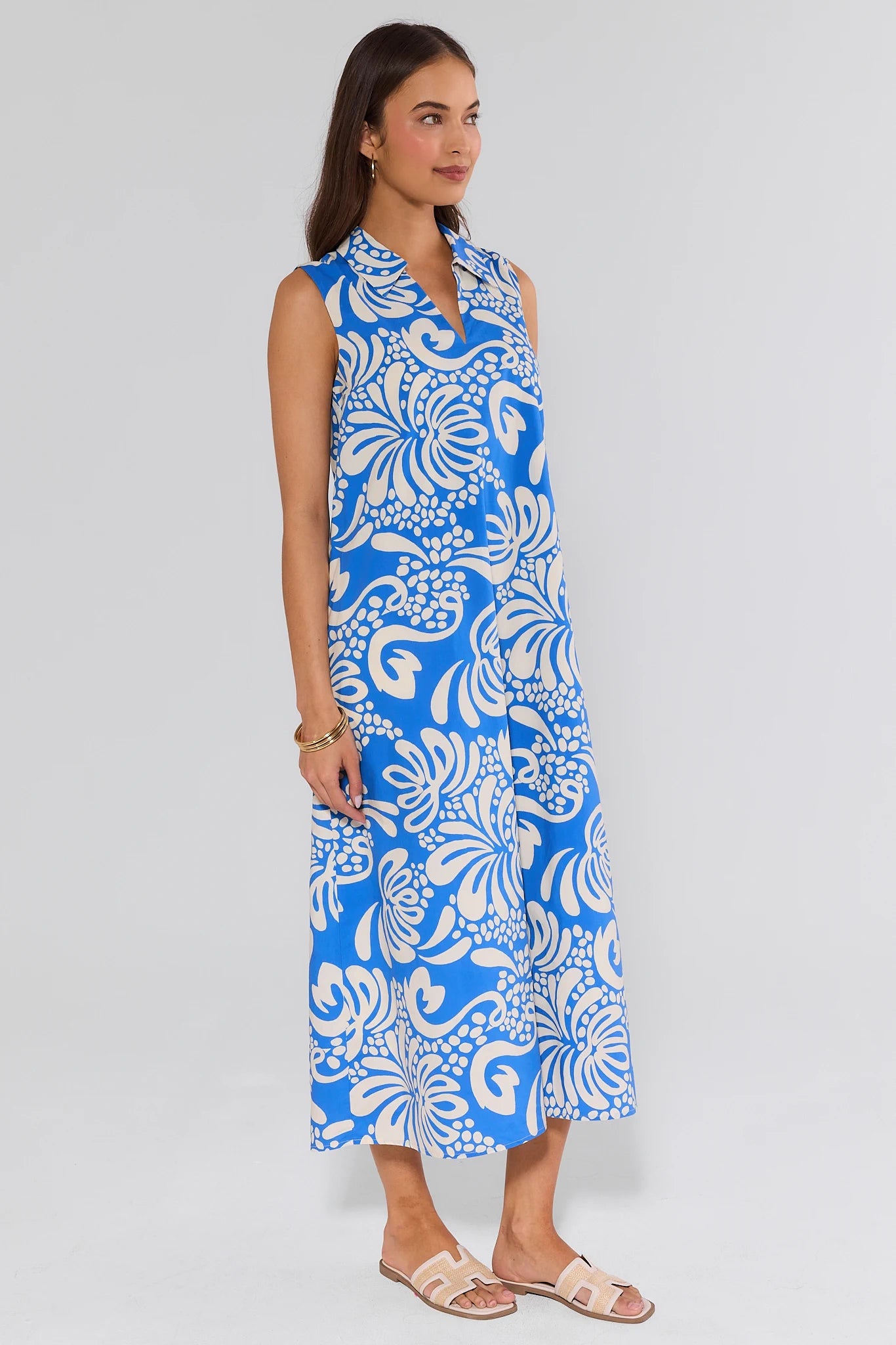 Woman wearing a blue and white floral dress on a light gray background