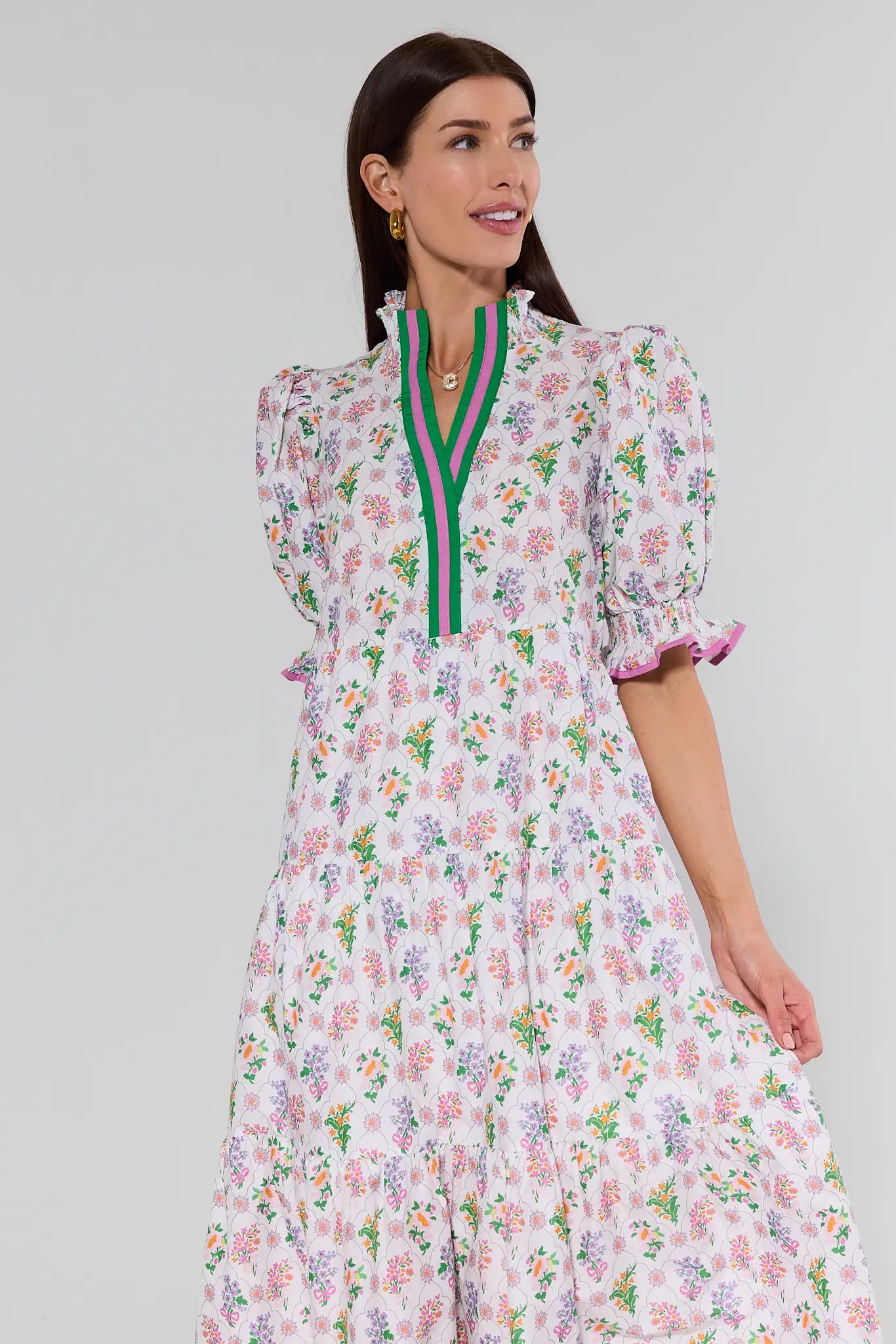 Woman wearing a floral dress with a green zipper on a gray background