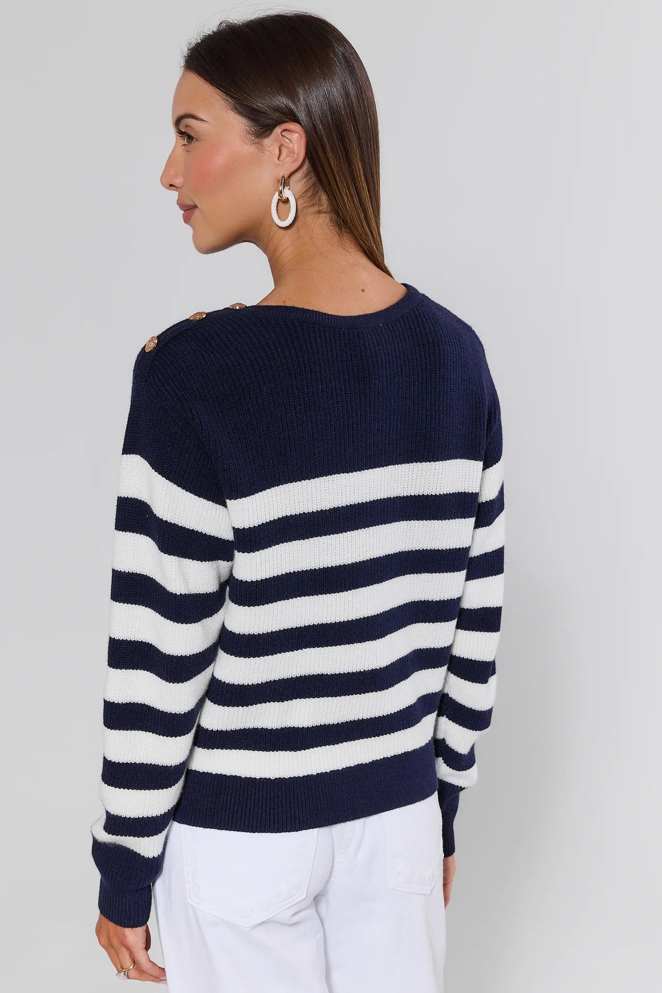 Woman wearing a navy and white striped sweater against a plain background
