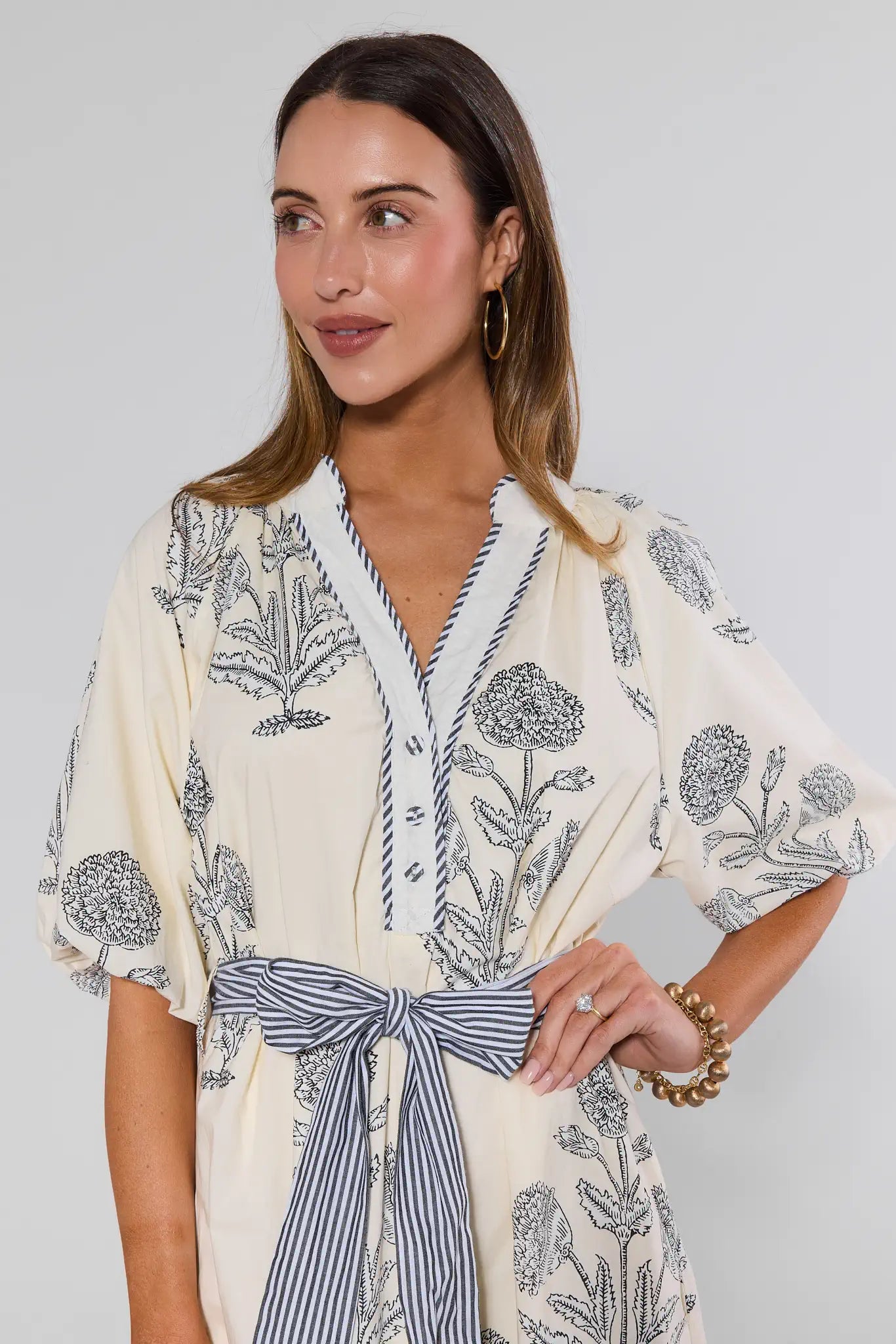 Woman wearing a floral kimono-style garment with a plain background