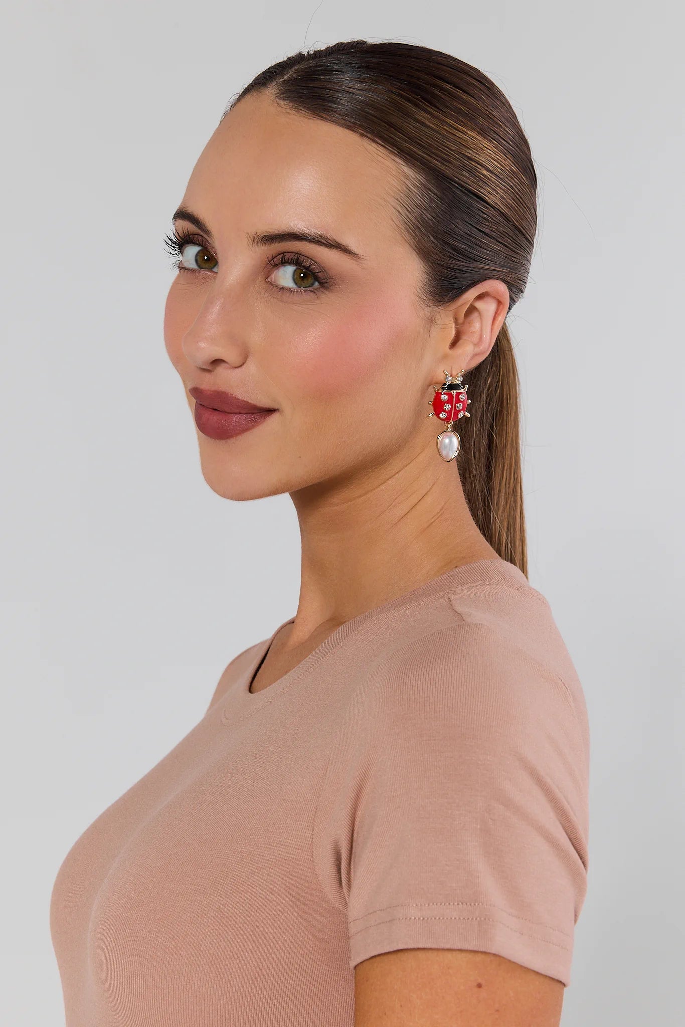 woman wearing Leighton Red Ladybug Earrings on white background