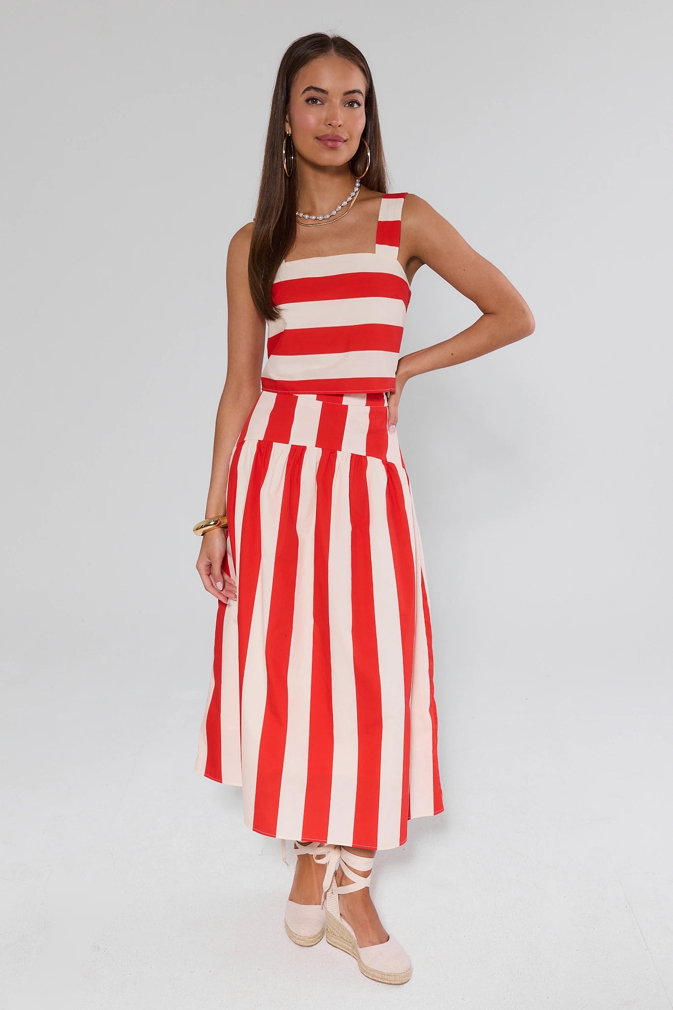 Woman wearing a red and white striped dress on a plain background