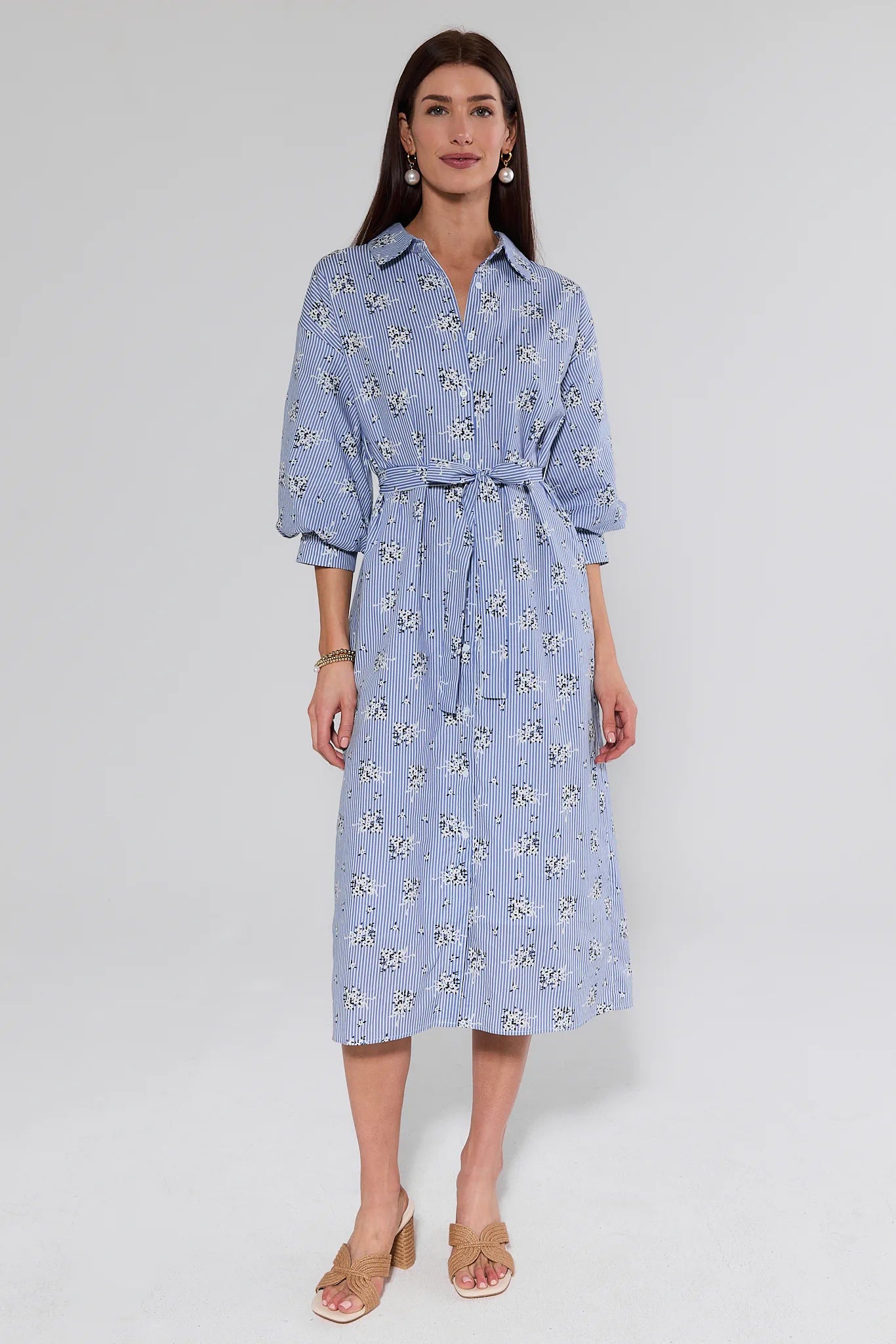 Woman wearing a blue floral dress on a light background