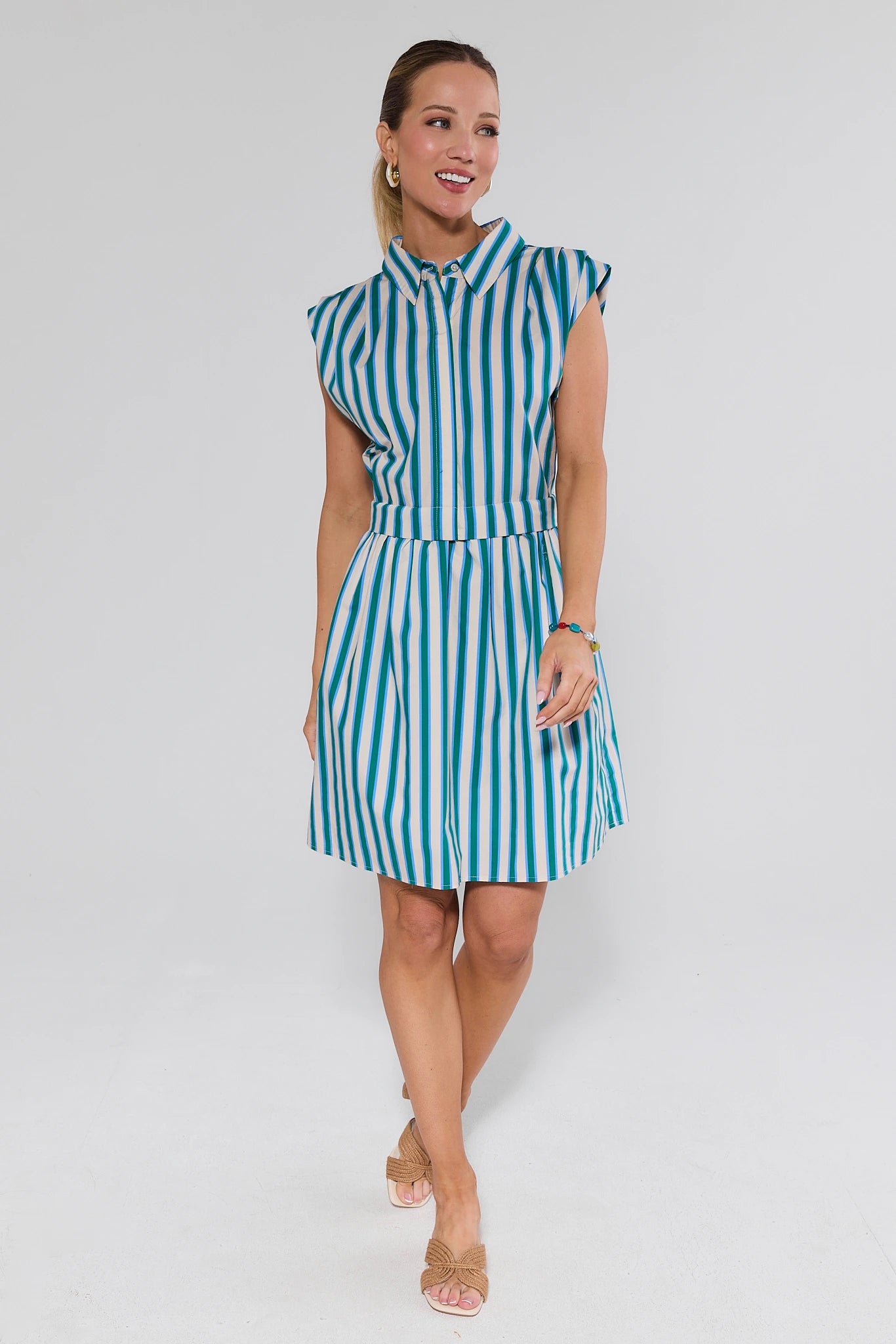Woman wearing a blue and white striped dress on a plain background
