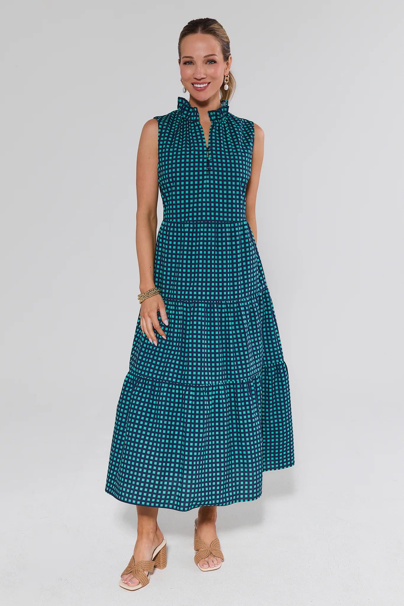 Woman wearing a teal patterned dress on a white background