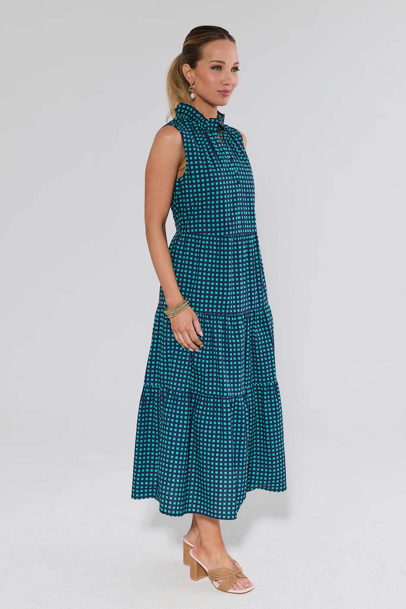 Woman wearing a teal patterned dress on a white background