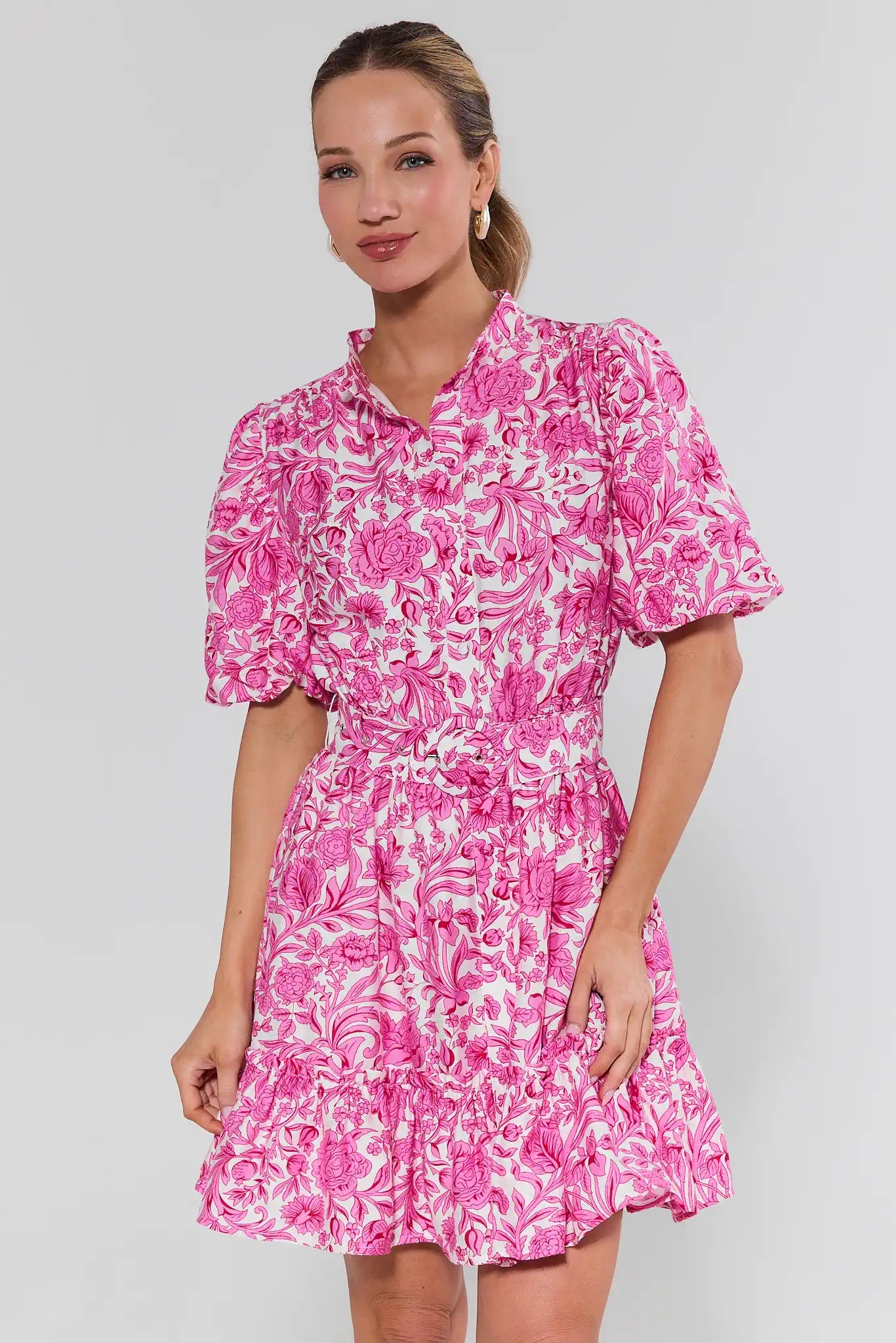 Woman wearing a pink floral dress against a white background