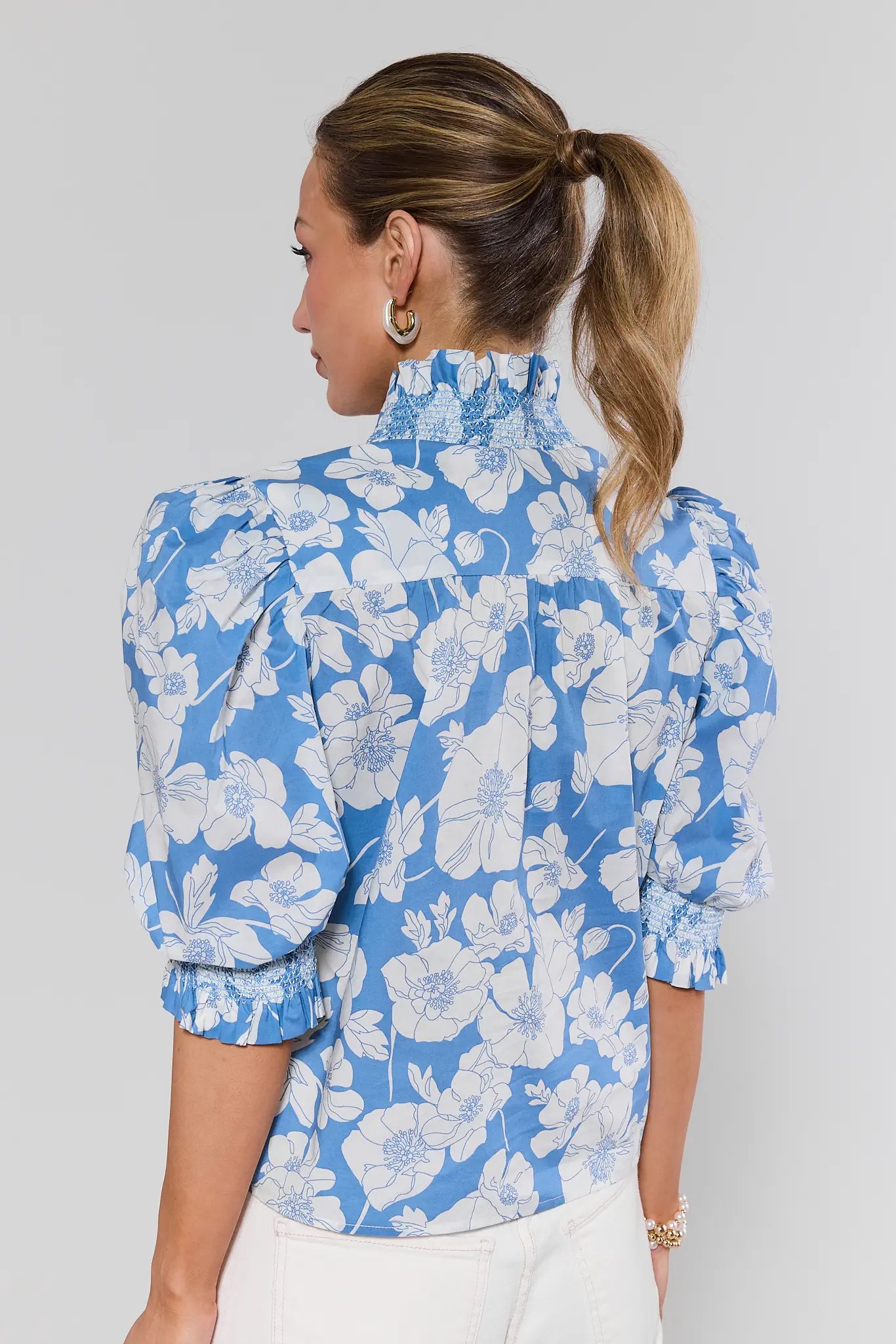 Woman wearing a blue floral blouse against a white background
