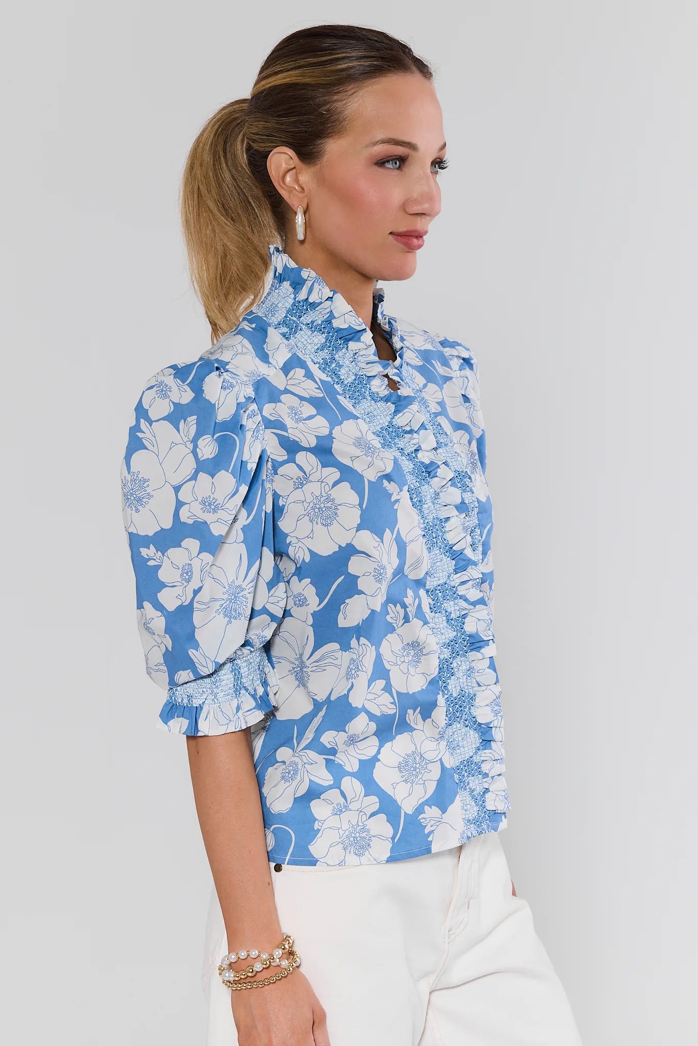 Woman wearing a blue floral blouse against a plain background