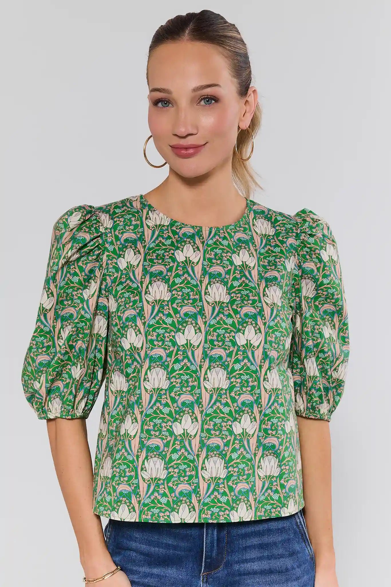 Woman wearing a green floral dress against a plain background