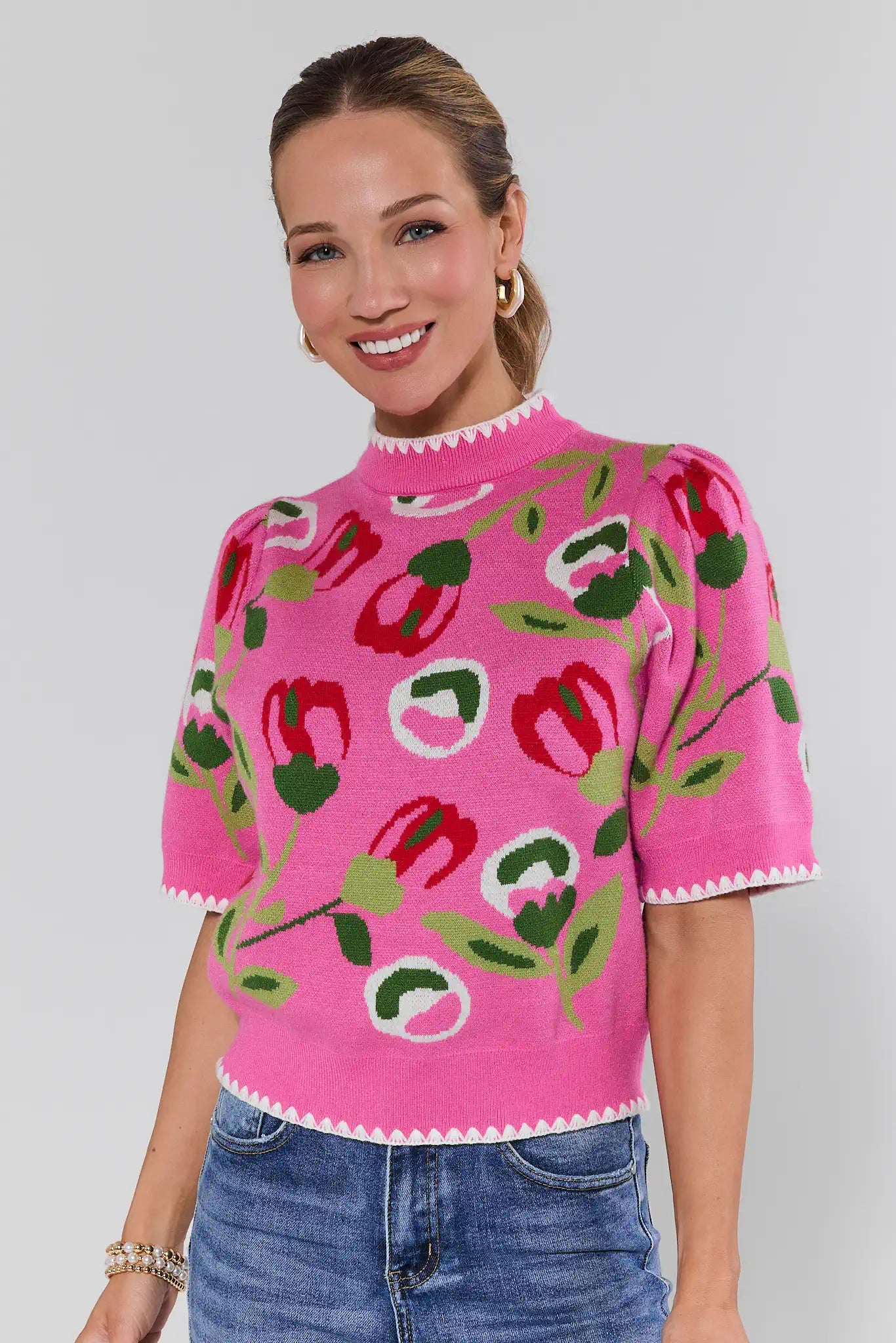 Woman wearing a pink floral-patterned top with a plain background