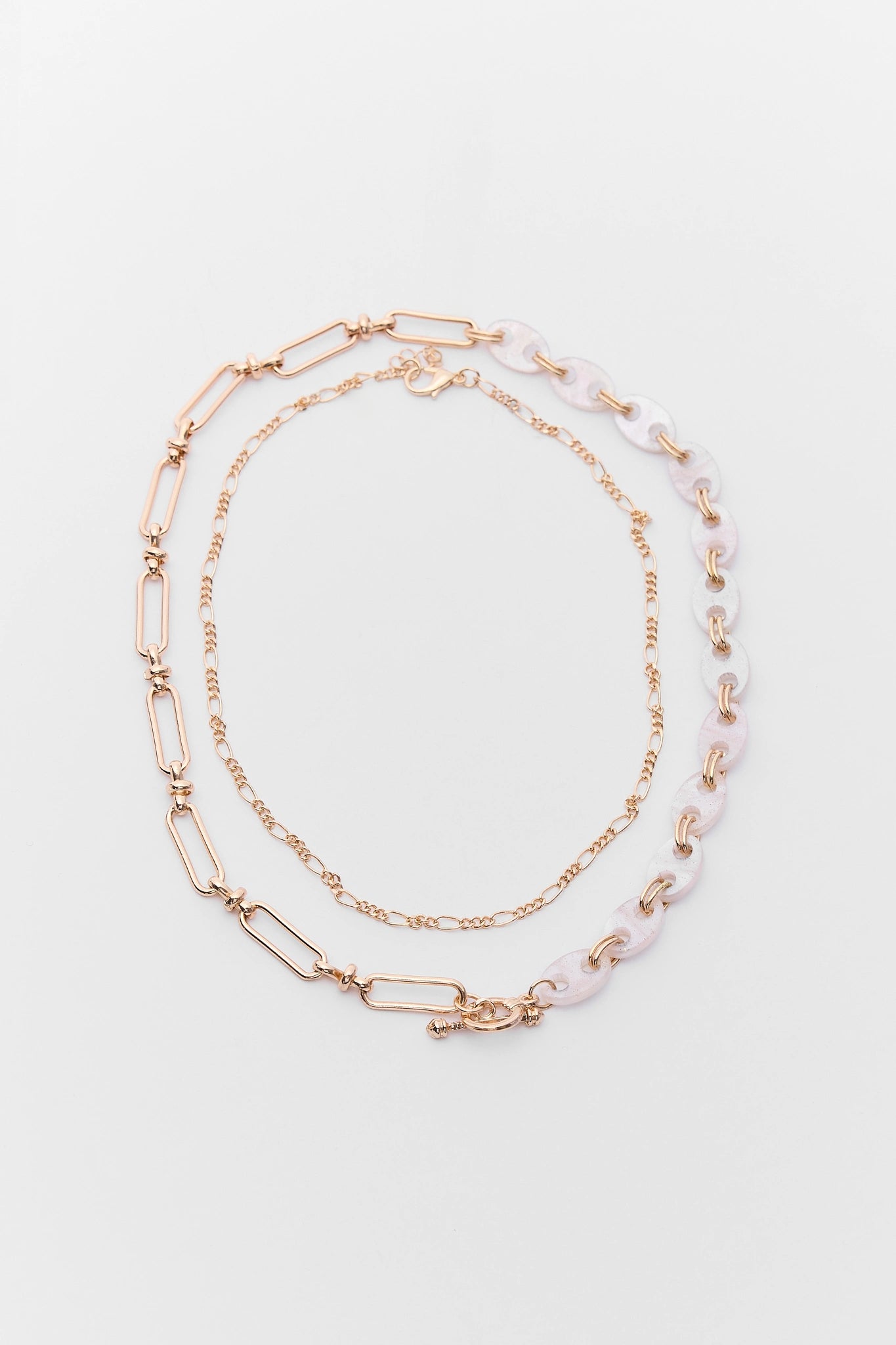 Two necklaces with gold and pink accents on a light gray background