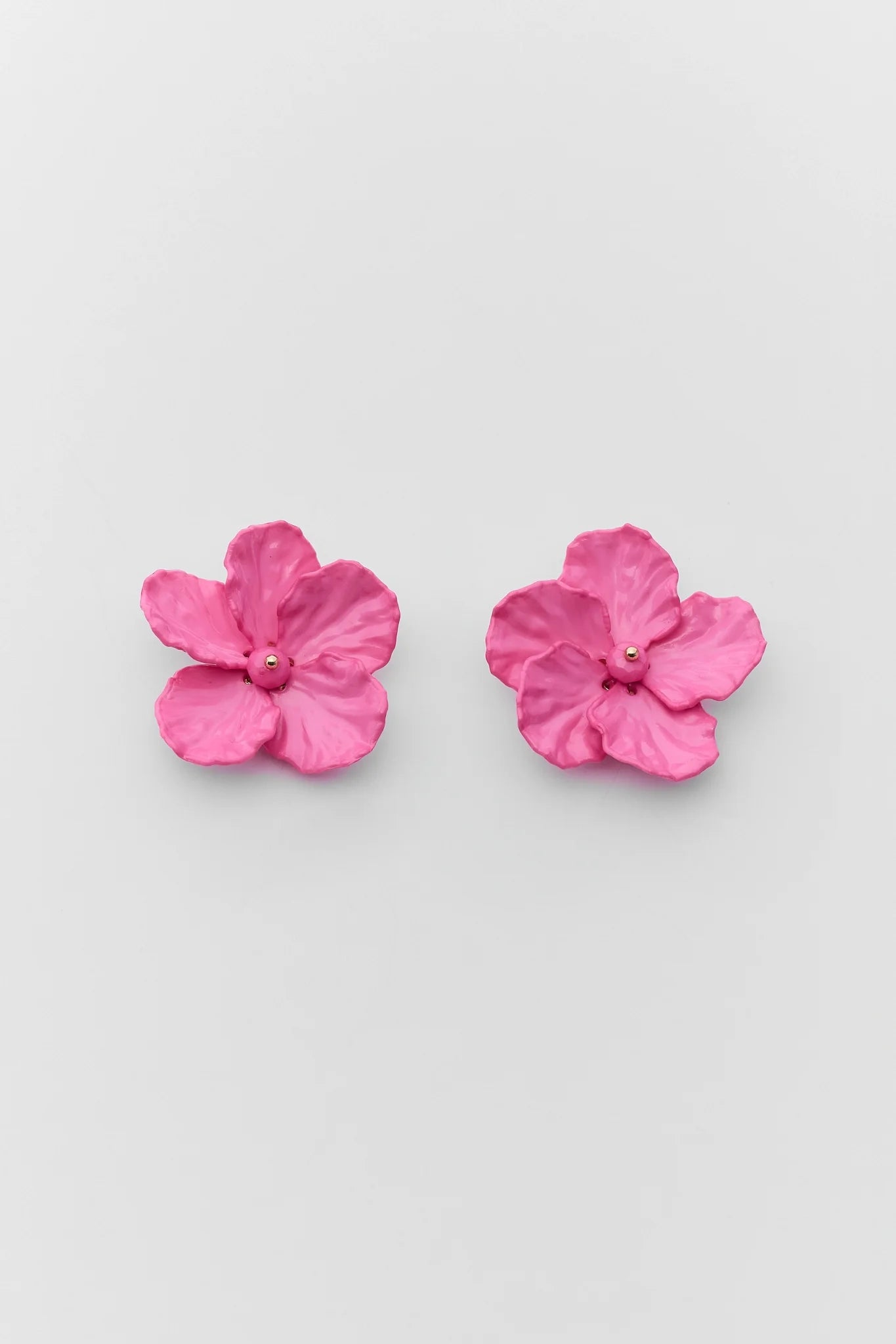 Pair of pink flower-shaped earrings on a light gray background