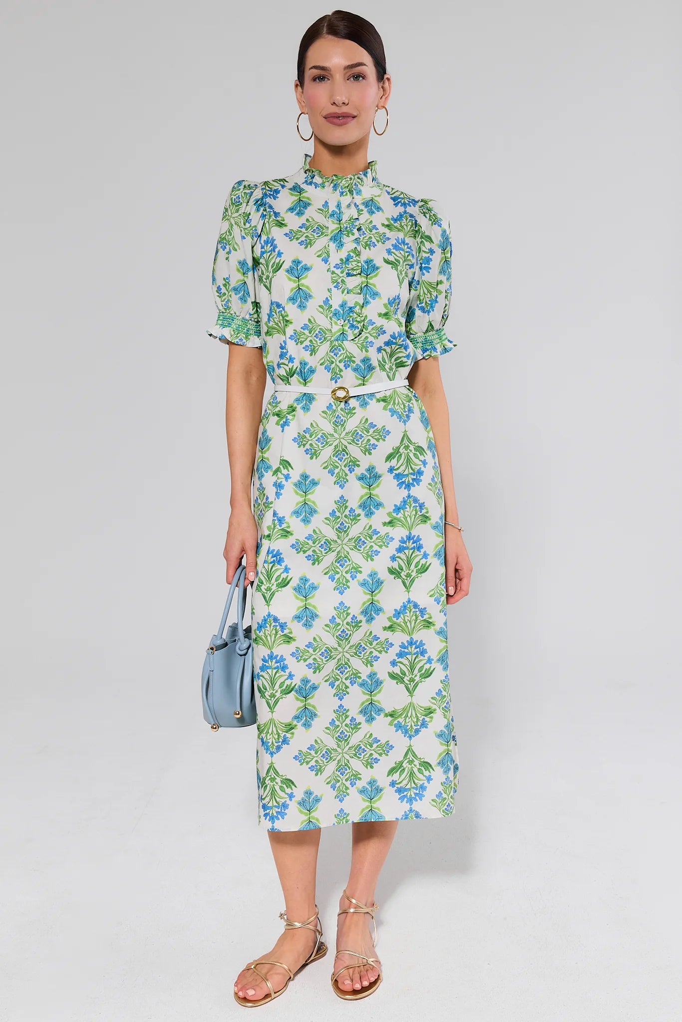 Woman wearing a floral dress belted with a white background