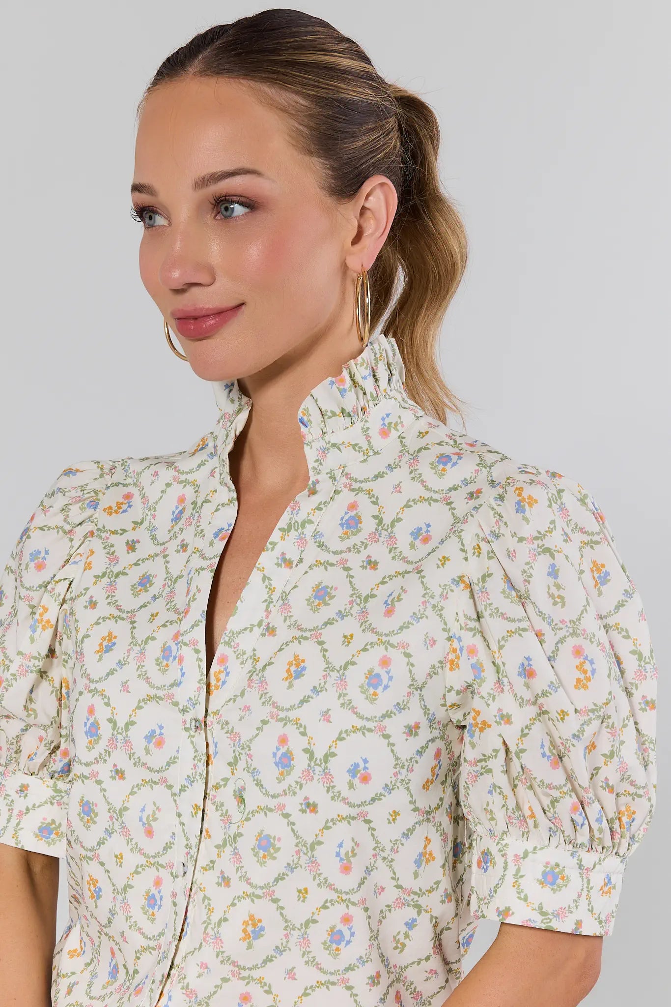 Woman wearing a floral blouse against a plain background