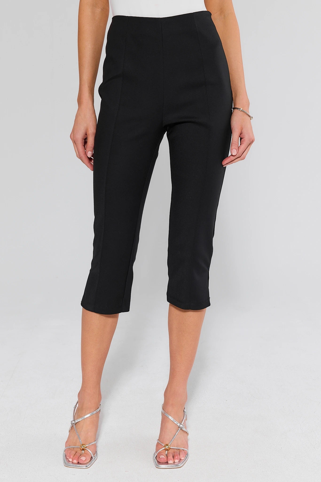 Person wearing black capri pants on a background