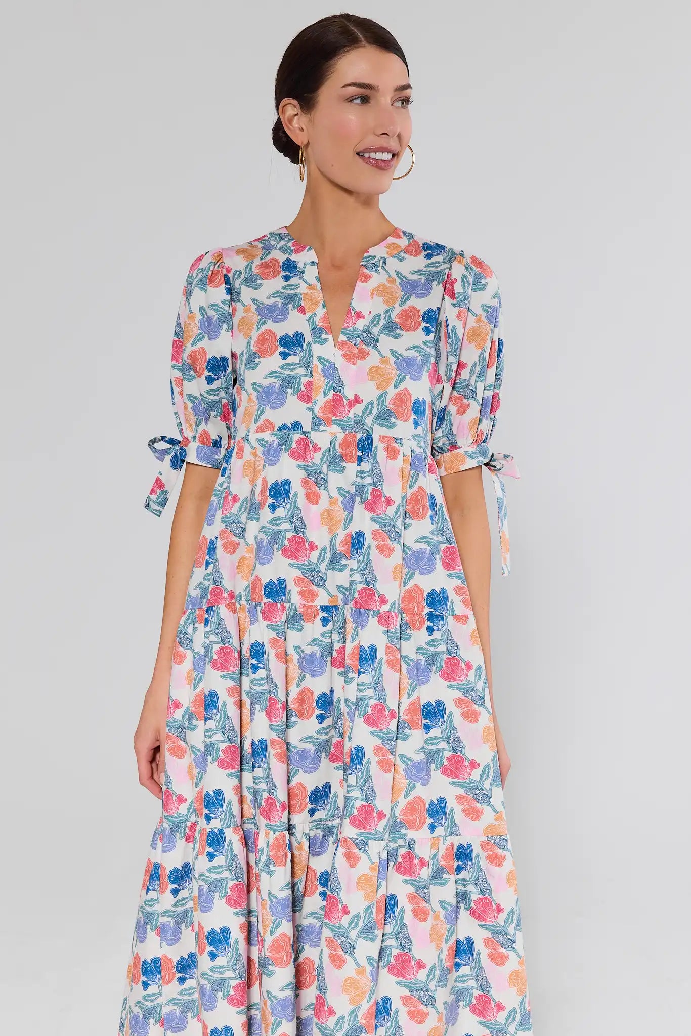 Woman wearing a floral dress against a plain background